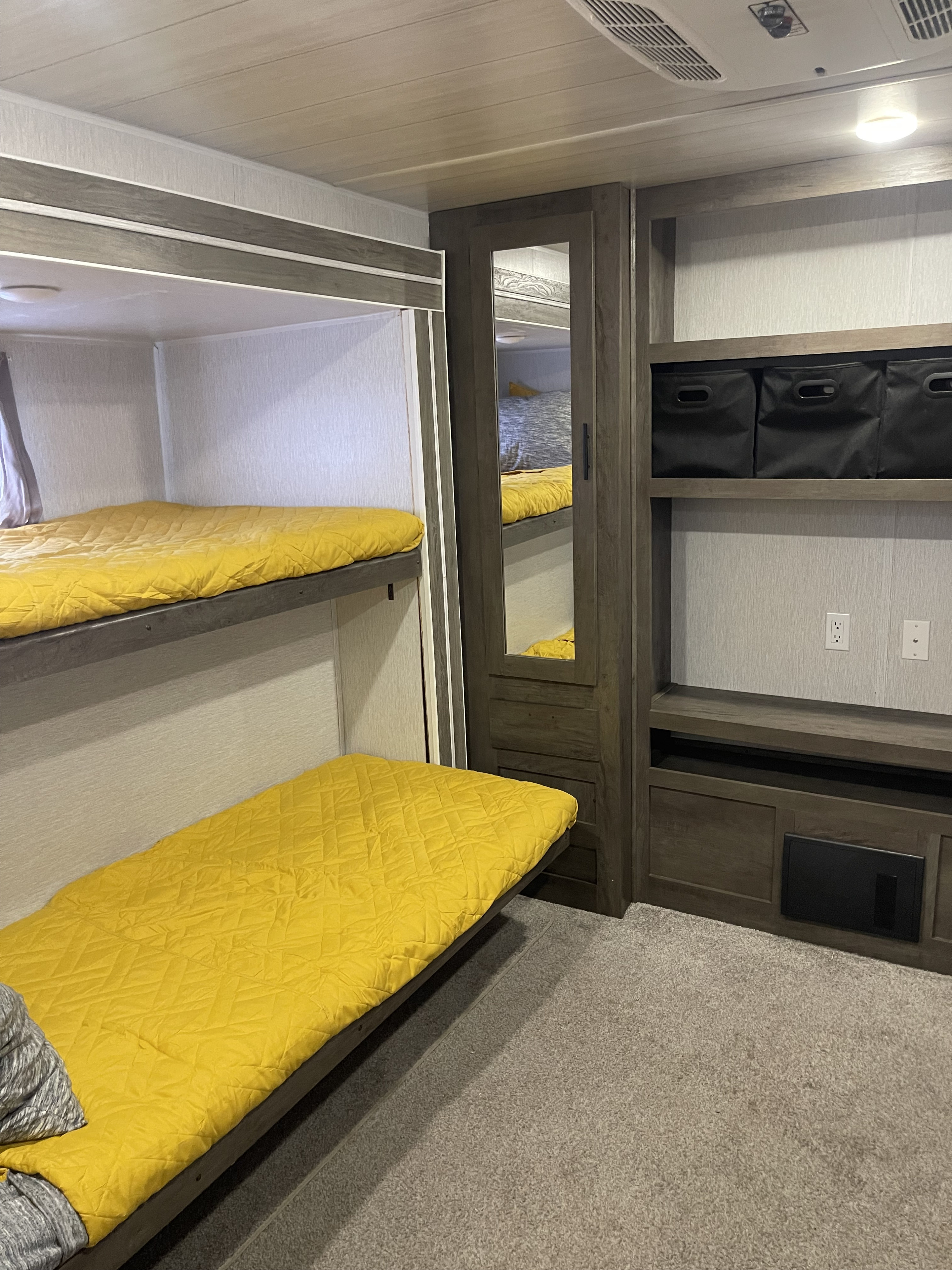 Inside an RV rental: twin bunk beds with yellow covers and integrated storage for a comfy stay.. Forest River Salem 2022