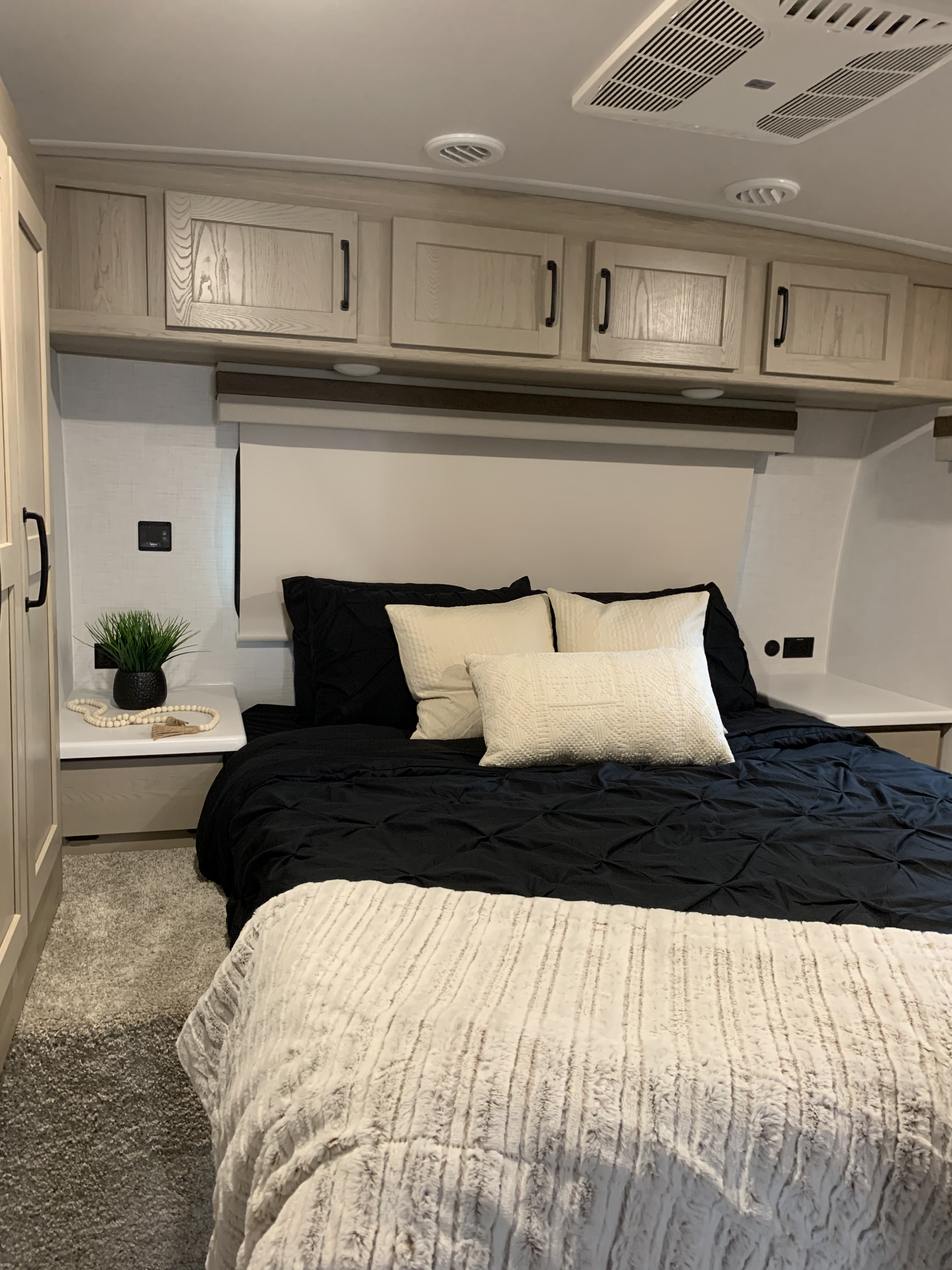 RV rental bedroom with a comfy bed, modern light wood cabinets, and soft textured carpet.. Forestriver Rockwood Ulta Lite 2706WS 2024