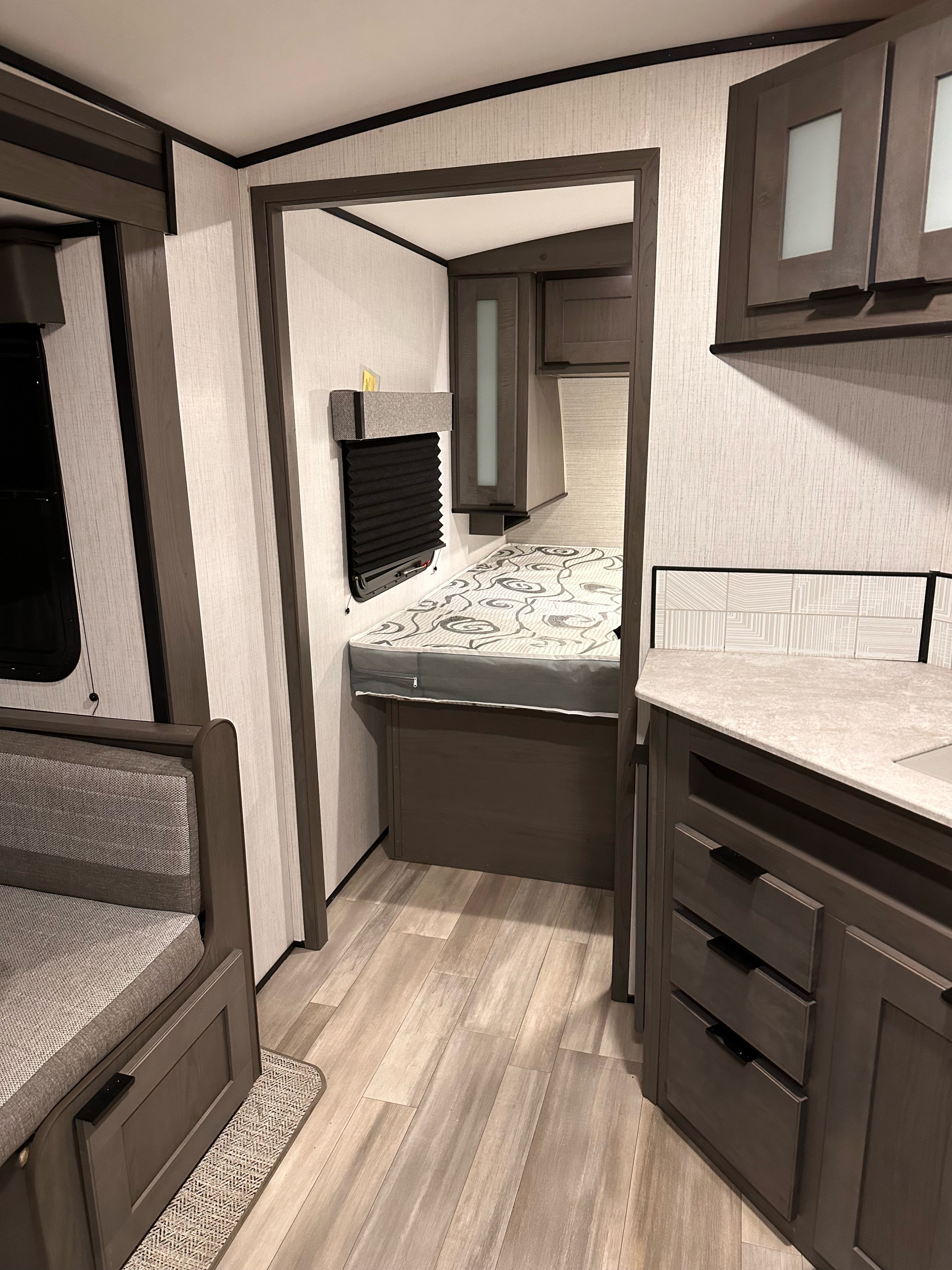 Spacious RV rental interior with a cozy bed bunk, comfortable dinette seating, and a functional kitchen counter. Perfect for road trips.. Cruiser RV MPG Ultra Lite 2022