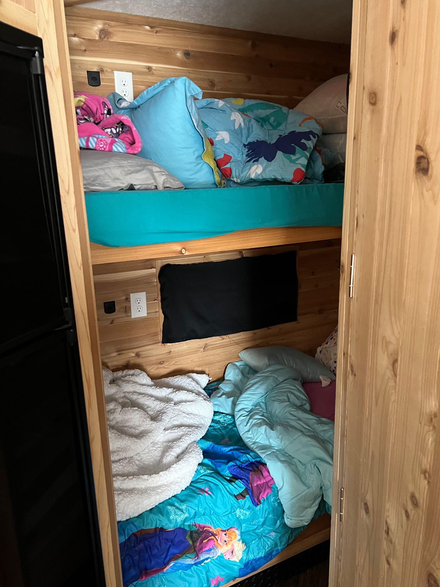 RV rental bunk beds: two cozy wood-paneled bunks with colorful bedding. Each bed has outlets for convenience.. Ice Castle Fish Houses Ice Castle Fish Houses Trailer 2022