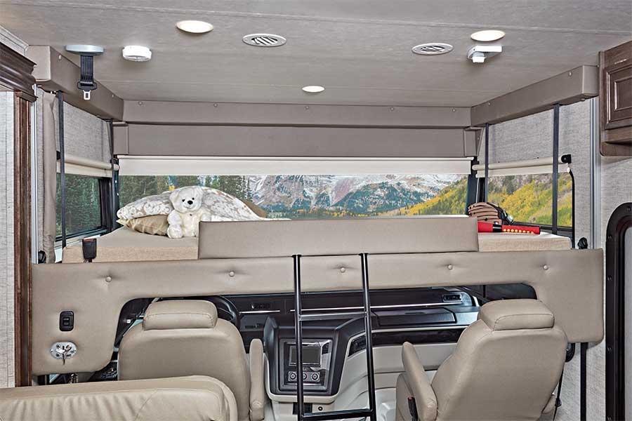 Spacious RV rental interior with cab-over bunk bed, driver's cabin, and scenic mountain views.. Entegra Coach Vision 2021