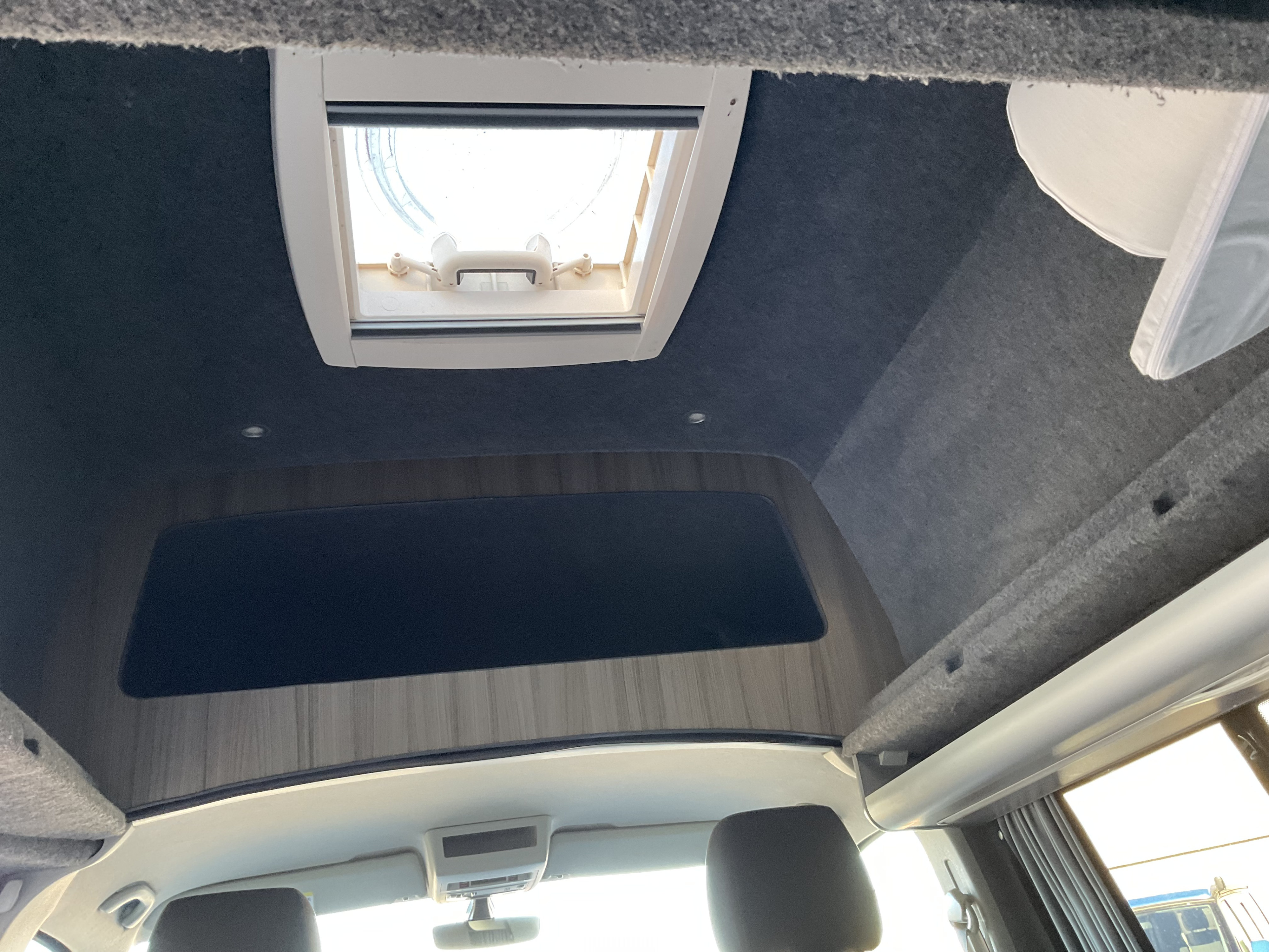 Looking up in an RV rental: Features include a bright skylight, gray ceiling, spotlights, and front cabin.. Volkswagen Transporter Stratherrick 2017