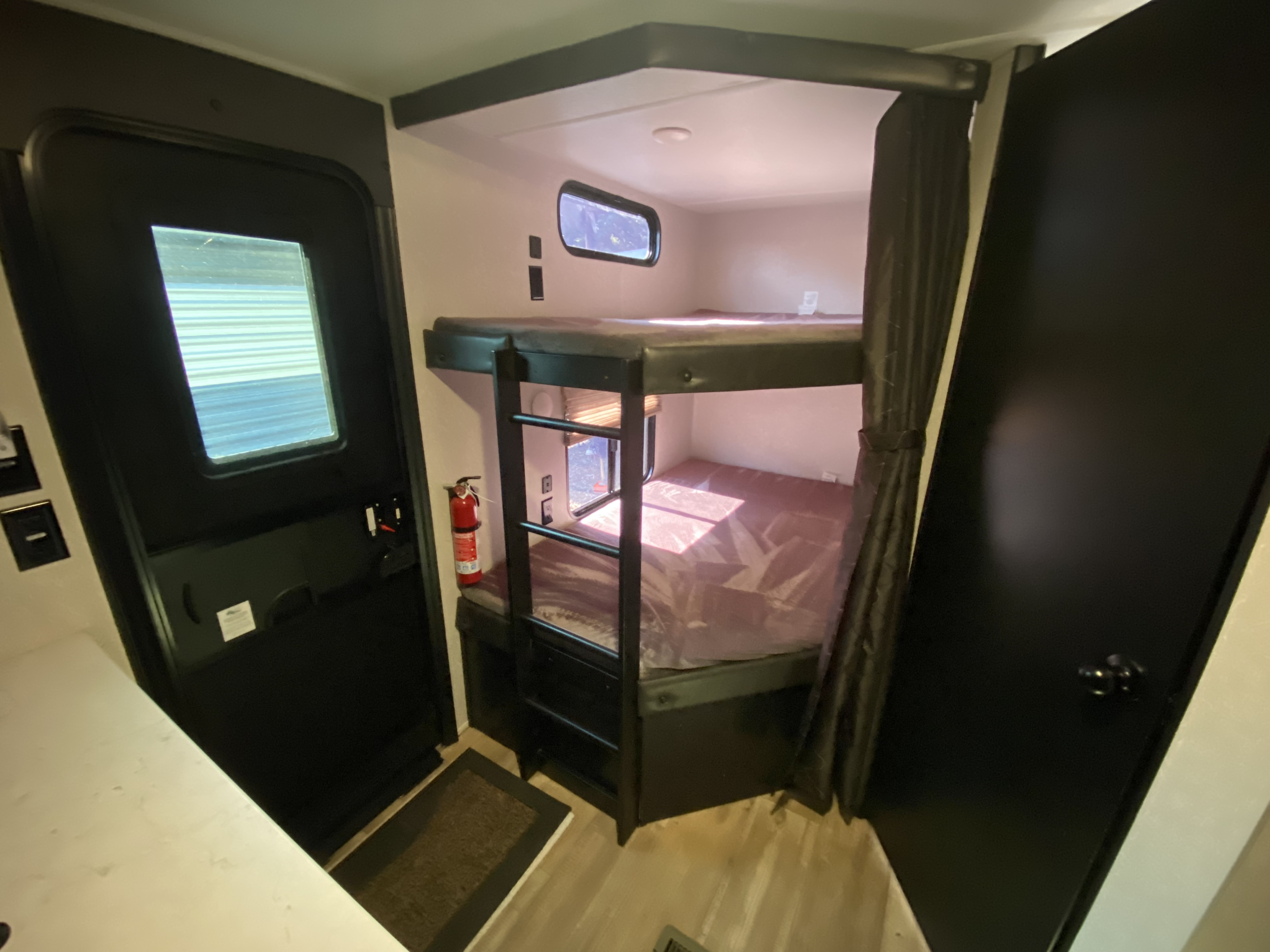 Inside this cozy rv rental: a practical layout with sturdy bunk beds, entry door, and a closet.. Forest River Cherokee 2021