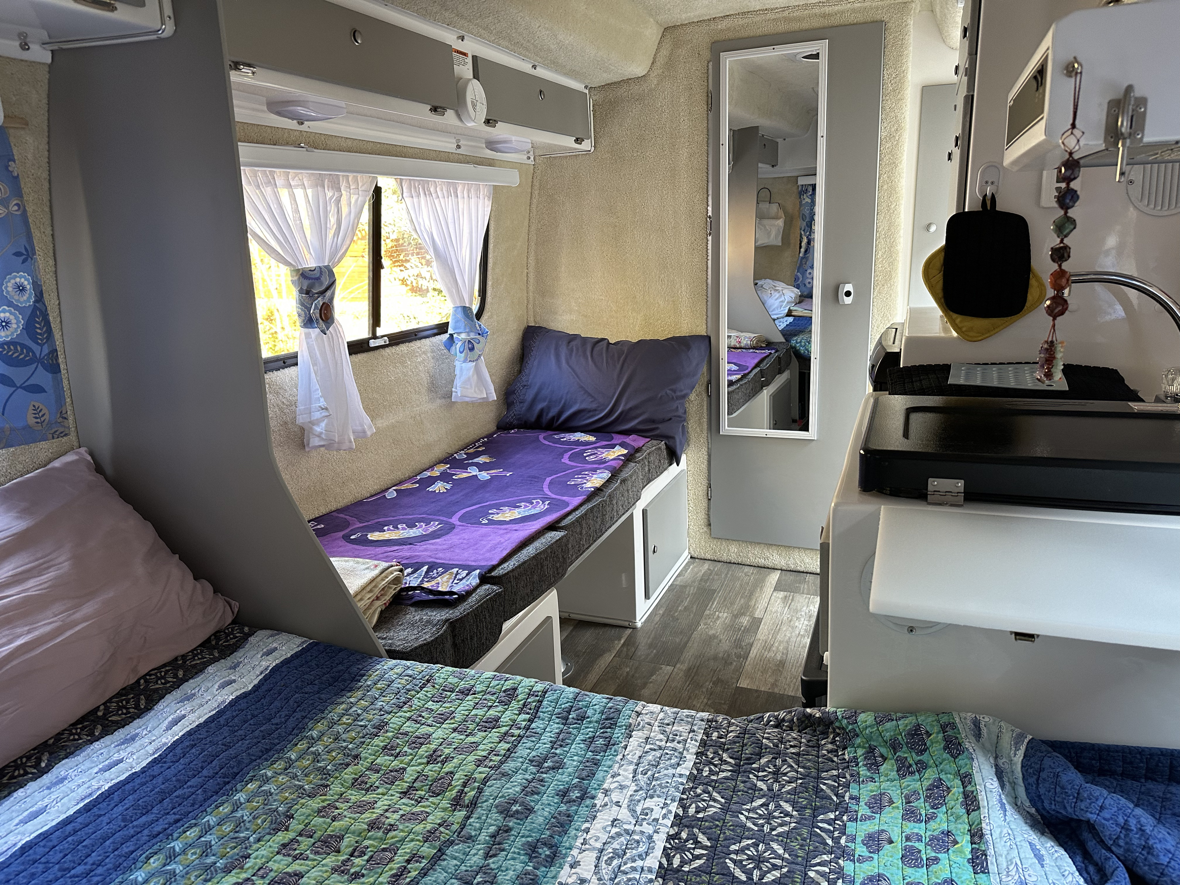 Cozy RV rental interior with a bunk bed, main bed, and compact kitchen, offering a functional and comfortable mobile living space.. Casita Spirit 2023