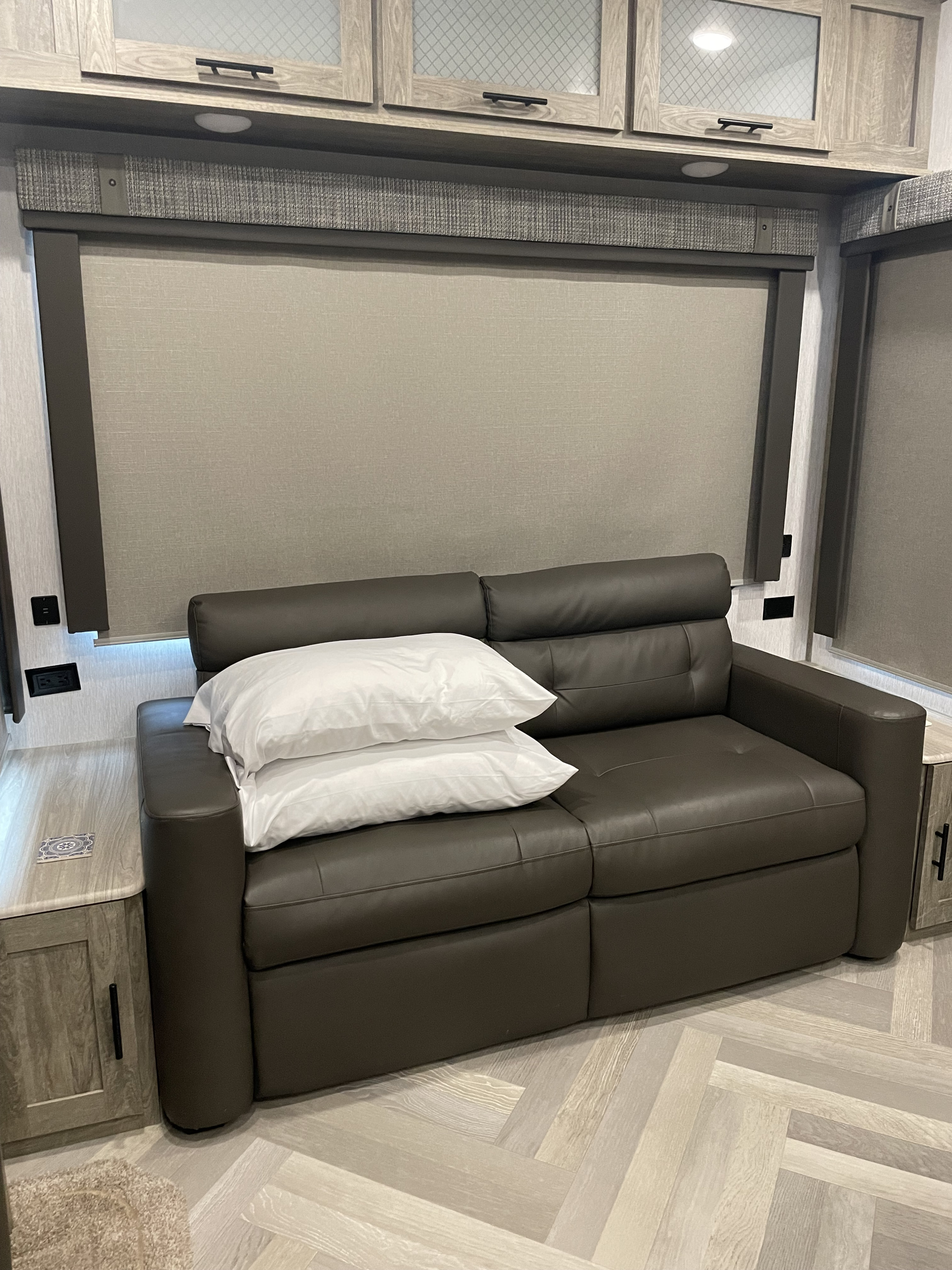 Experience this RV rental's cozy interior: dark sofa, white pillows, wood-grain cabinets, and sleek light-toned window blinds.. Forest River Salem Hemisphere 2022