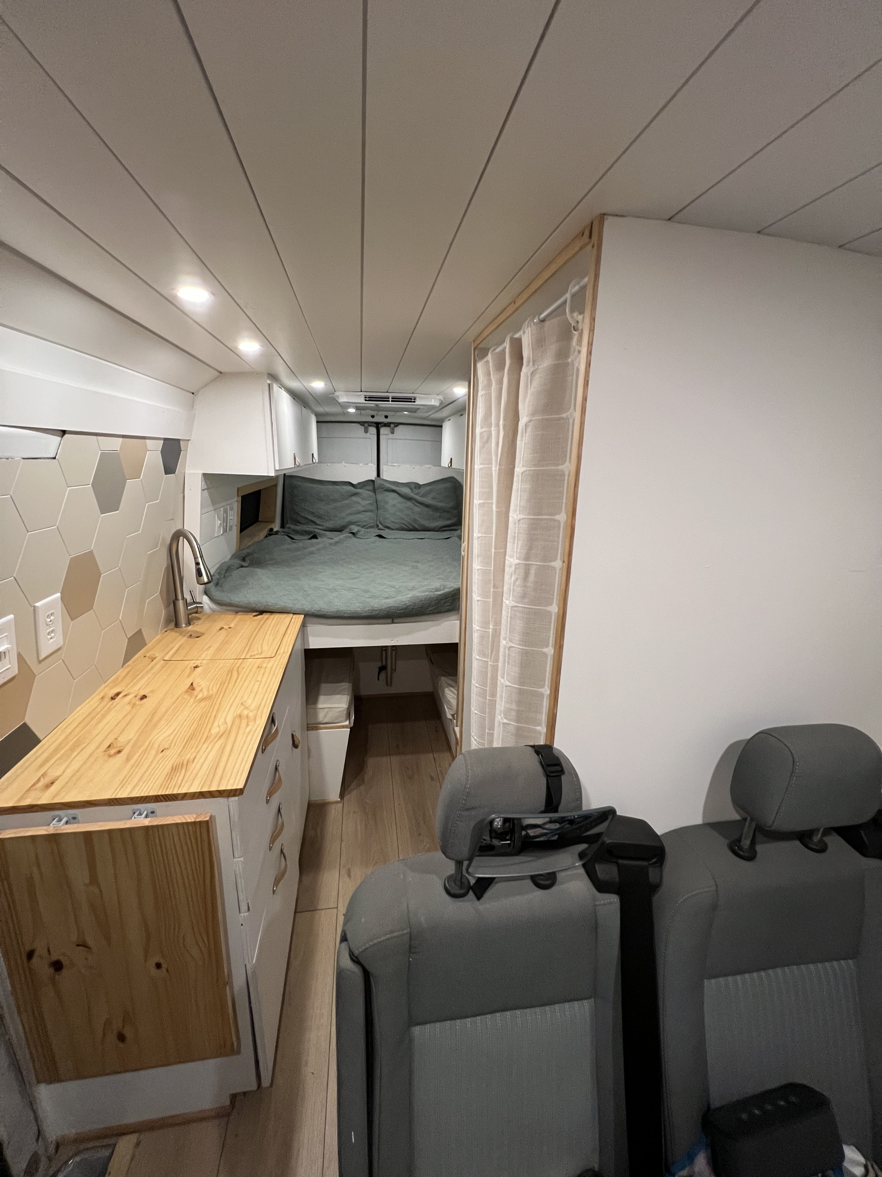 RV rental interior: kitchen with sink, bed, and private curtained area. Includes front seats.. Mercedes Sprinter 2004