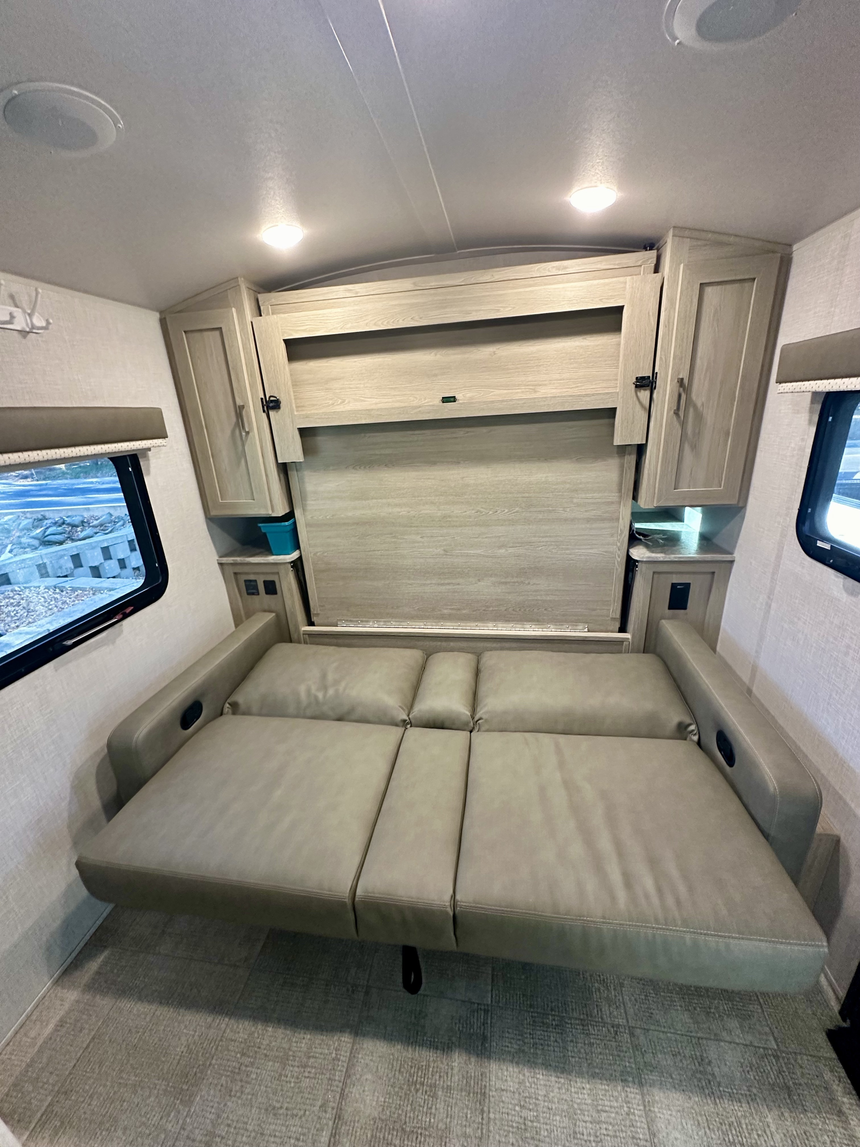 Versatile RV rental interior: a space-saving sofa that converts to a bed, flanked by convenient storage cabinets.. Forest River Geo Pro 2021