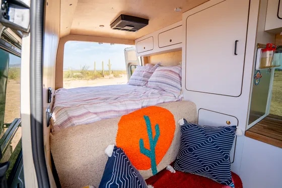 Cozy RV rental interior featuring a comfy bed, smart storage, and stunning desert views with saguaro cacti.. VanCraft VanCraft Class B 2022