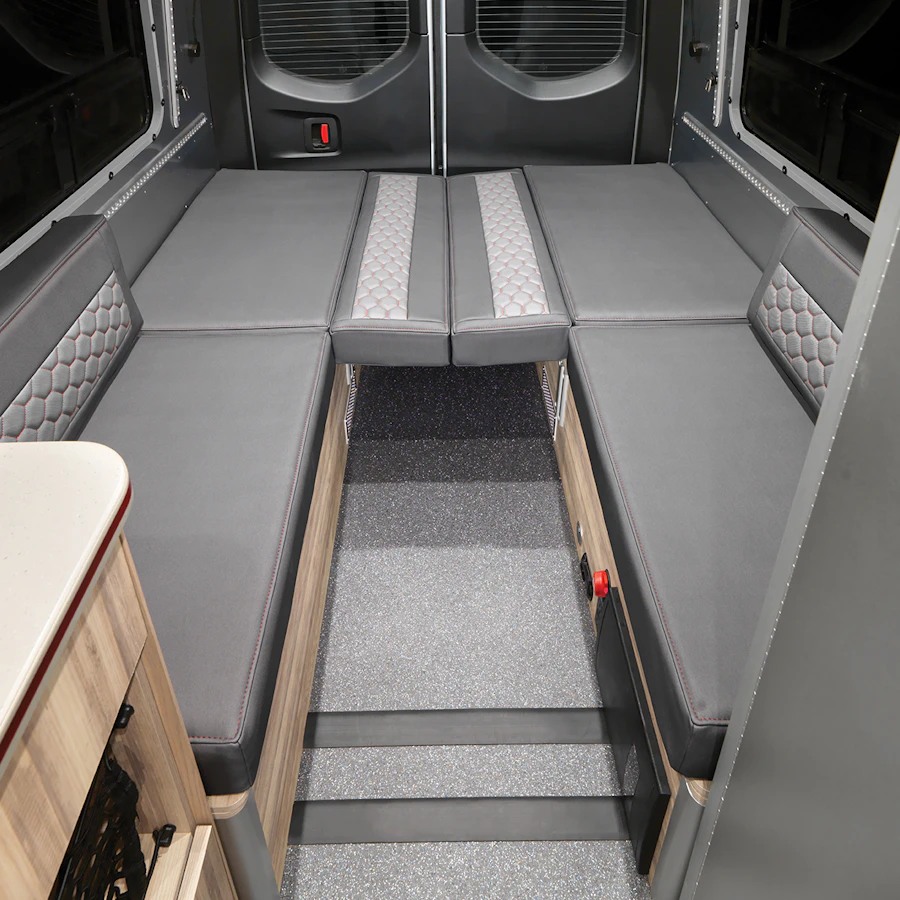 RV rental: Versatile gray U-shaped seating transforms into a comfortable bed, ready for your adventures. Ideal for camper van interiors.. Airstream Interstate 2022