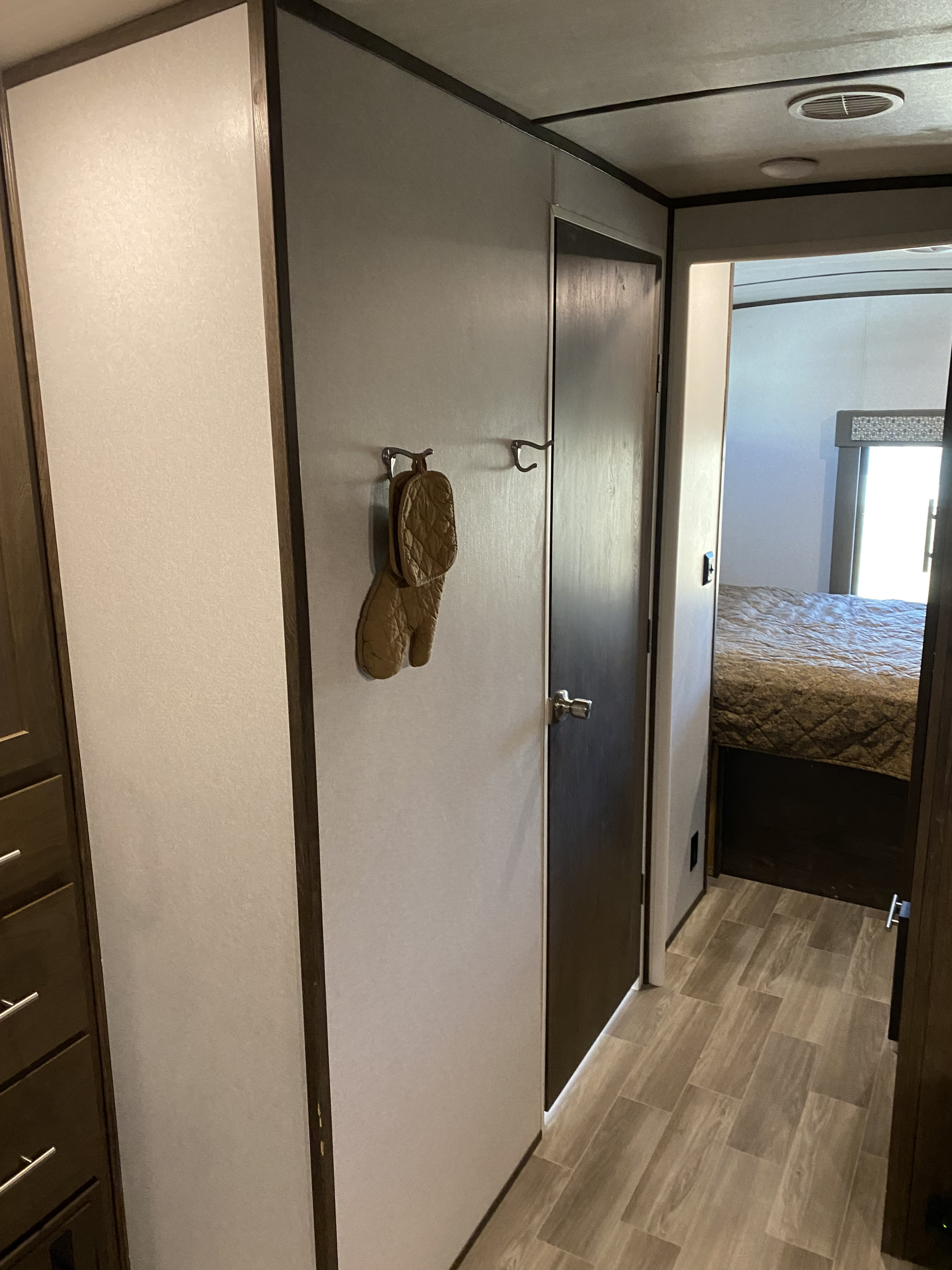 RV rental interior hallway with oven mitt, leading to cozy bedroom. Wood-look flooring provides a homey feel.. Forest River Salem Hemisphere GLX 2019