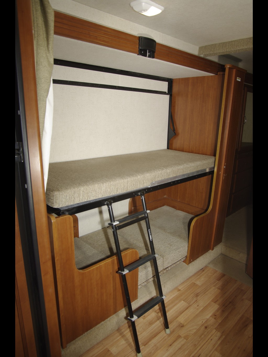 RV rental interior: cozy bunk beds with a ladder and comfortable mattresses. Perfect compact sleeping for your trip.. Fleetwood Encounter 32BH 2010