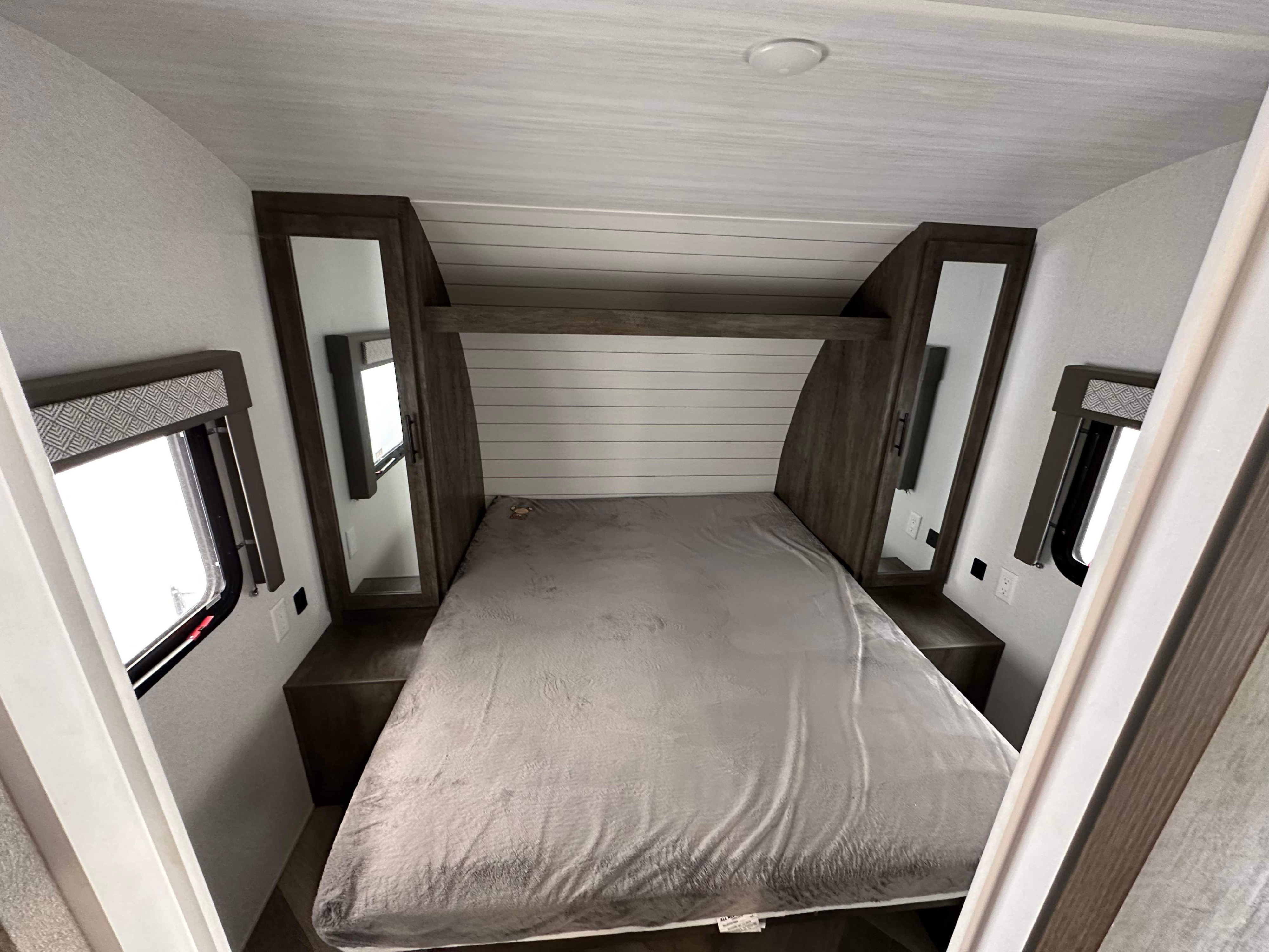 Modern RV rental bedroom: light walls, shiplap headboard, mirrored closets, and comfy bed.. Forest River Salem Cruise Lite 2020