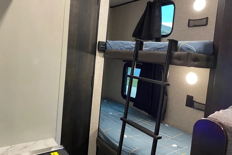 RV rental interior: Comfortable bunk beds with windows, lighting, and storage nets for a great camping trip.. Jayco Jay Flight SLX 2022