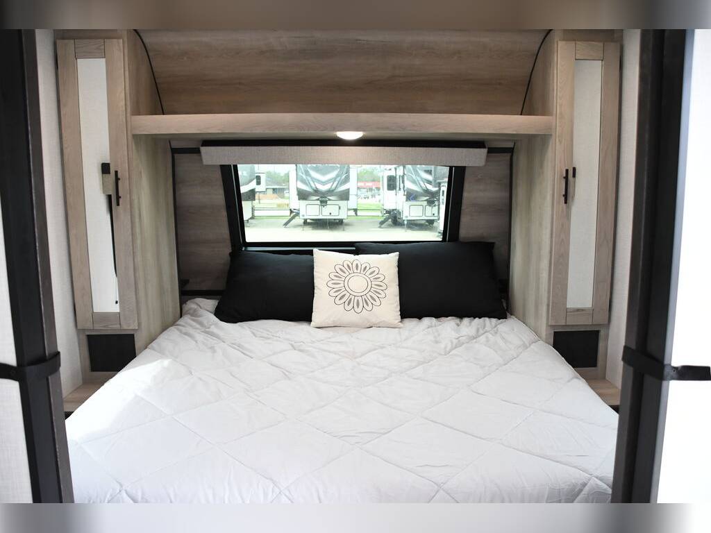 Spacious RV rental bedroom featuring a comfortable bed, mirrored cabinets, and a window view.. KZ Connect C291BHK 2023