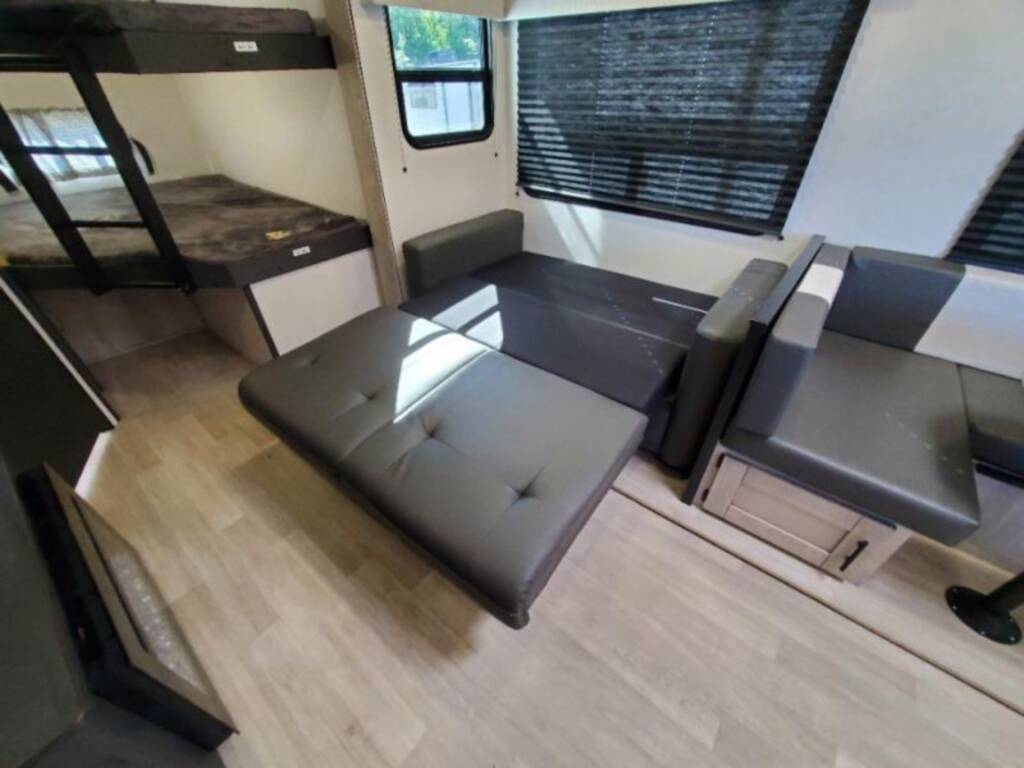 Spacious RV rental interior: bunk beds, convertible sofa, and dinette for flexible living and sleeping.. KZ Connect C291BHK 2023