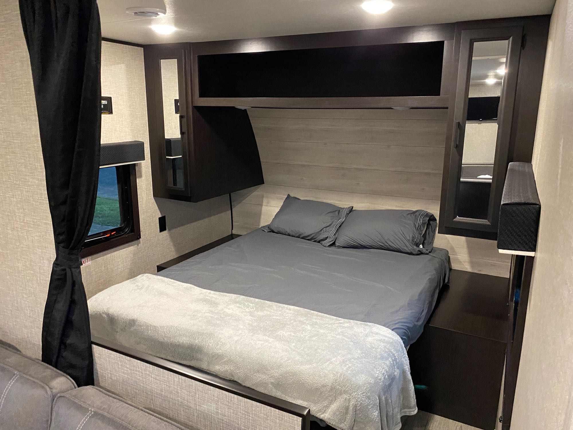 This RV rental bedroom offers a comfortable bed, overhead storage, and a window, designed for cozy travel accommodations.. Jayco Jay Flight 2023