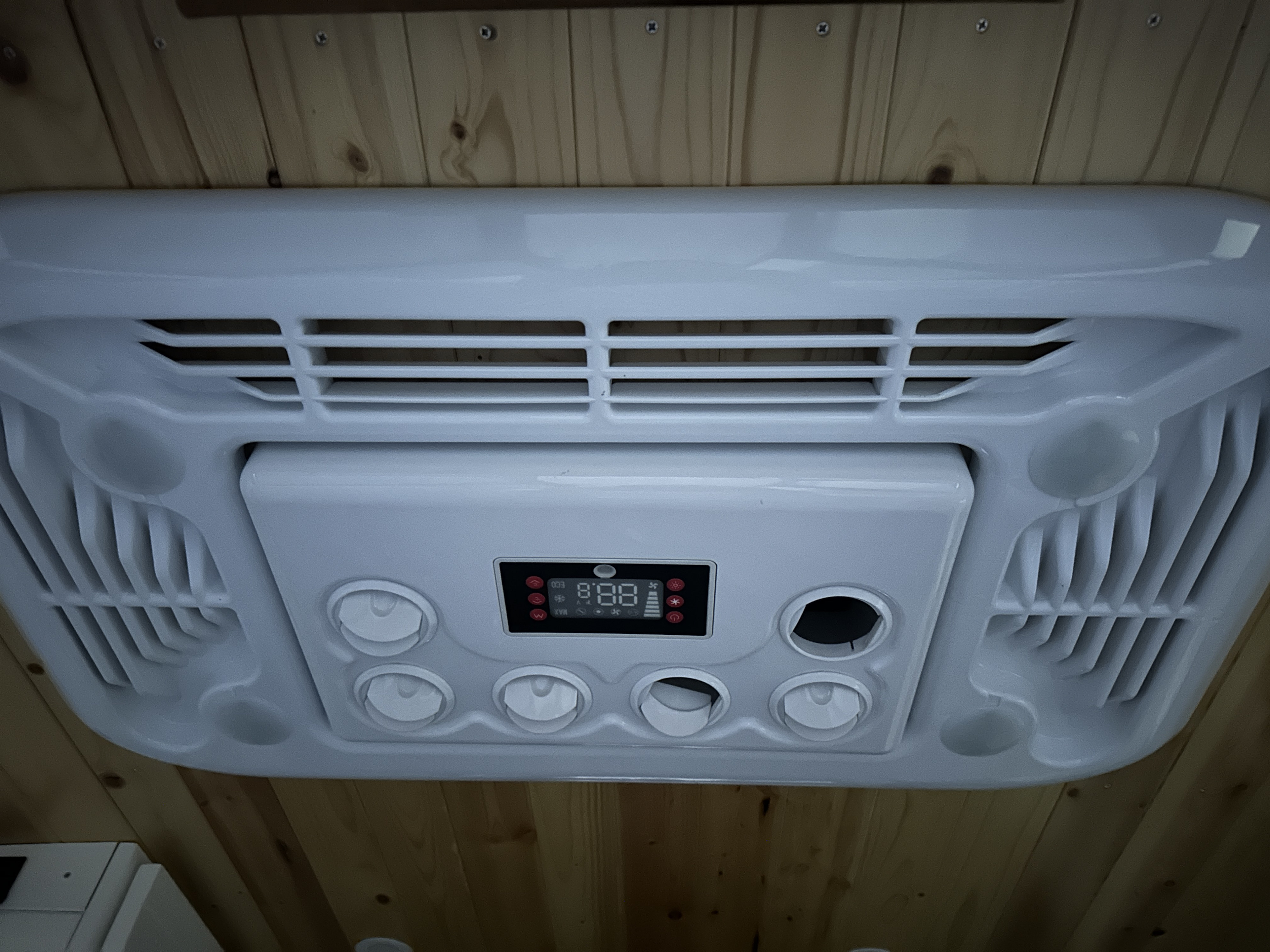 RV rental climate control unit with digital temp (88.8) and vents, mounted on a wood-paneled ceiling for comfort.. Ram Promaster 2500 Promaster 2500 2018