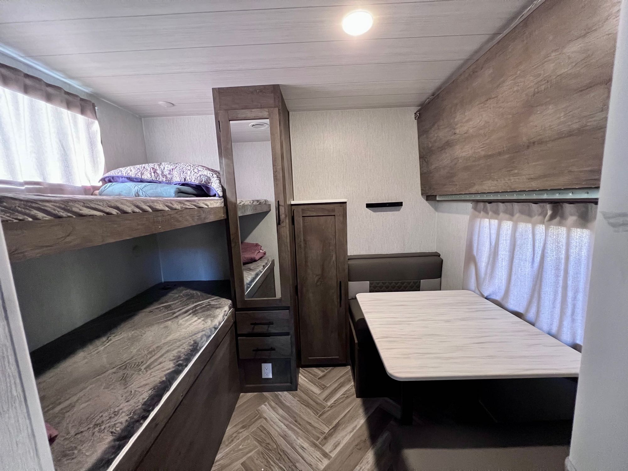 RV rental's functional interior: a bunk bed area, convertible dinette table, and integrated storage for compact living.. Forest River T30qbss 2022