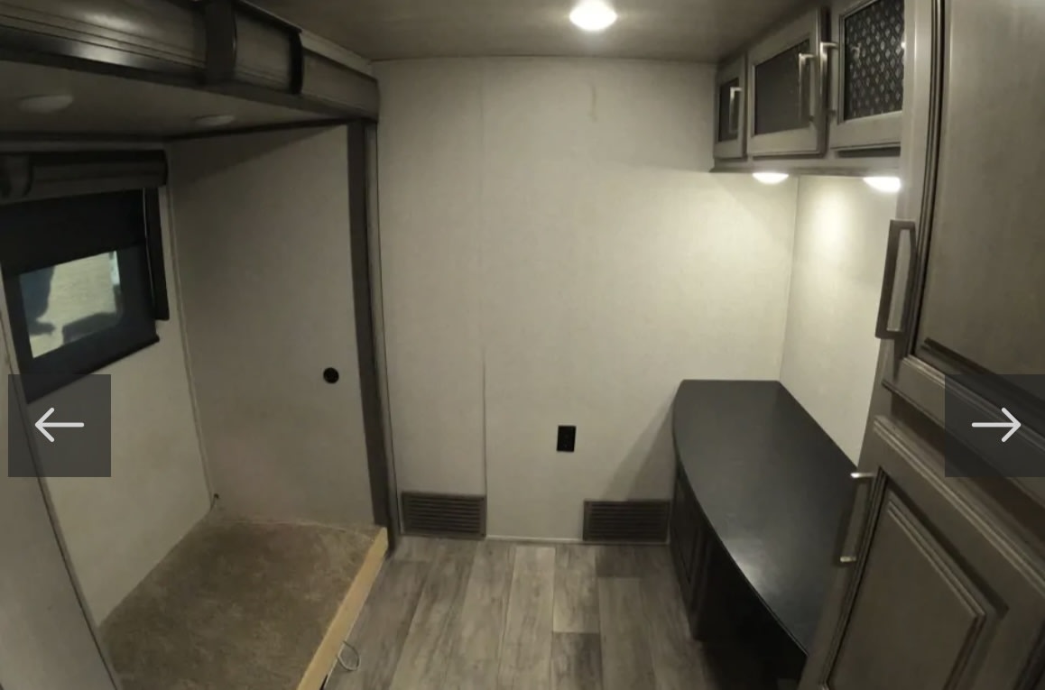 RV rental interior showcasing a bunk bed, window, and wall vents. Modern cabinets and a curved counter complete the space.. Keystone RV Montana 2021