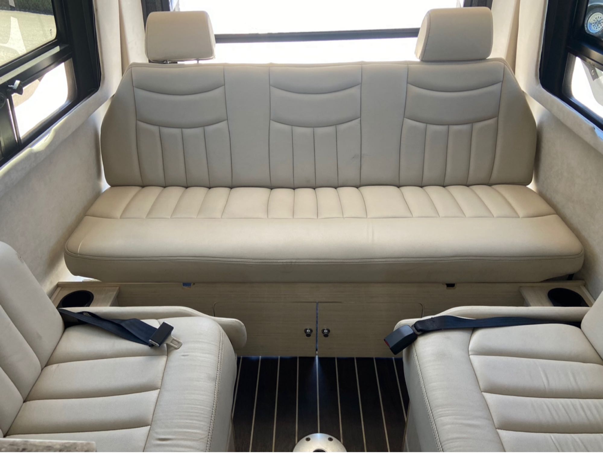 RV rental's luxurious beige interior with a comfortable rear bench and two individual front seats, all with safety belts.. Airstream Interstate 2015