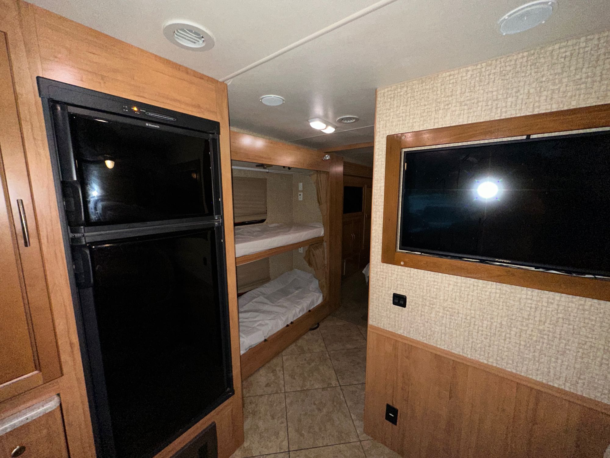 Inside this RV rental: convenient fridge, comfortable bunk beds, and a TV for entertainment on your journey.. Coachman Miranda 2015