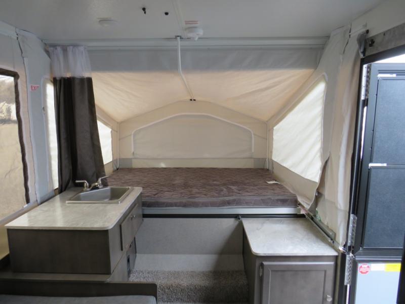 Inside an RV rental, this pop-up camper features a bed, sink, and compact living area for your adventures.. Forest River Flagstaff 2020