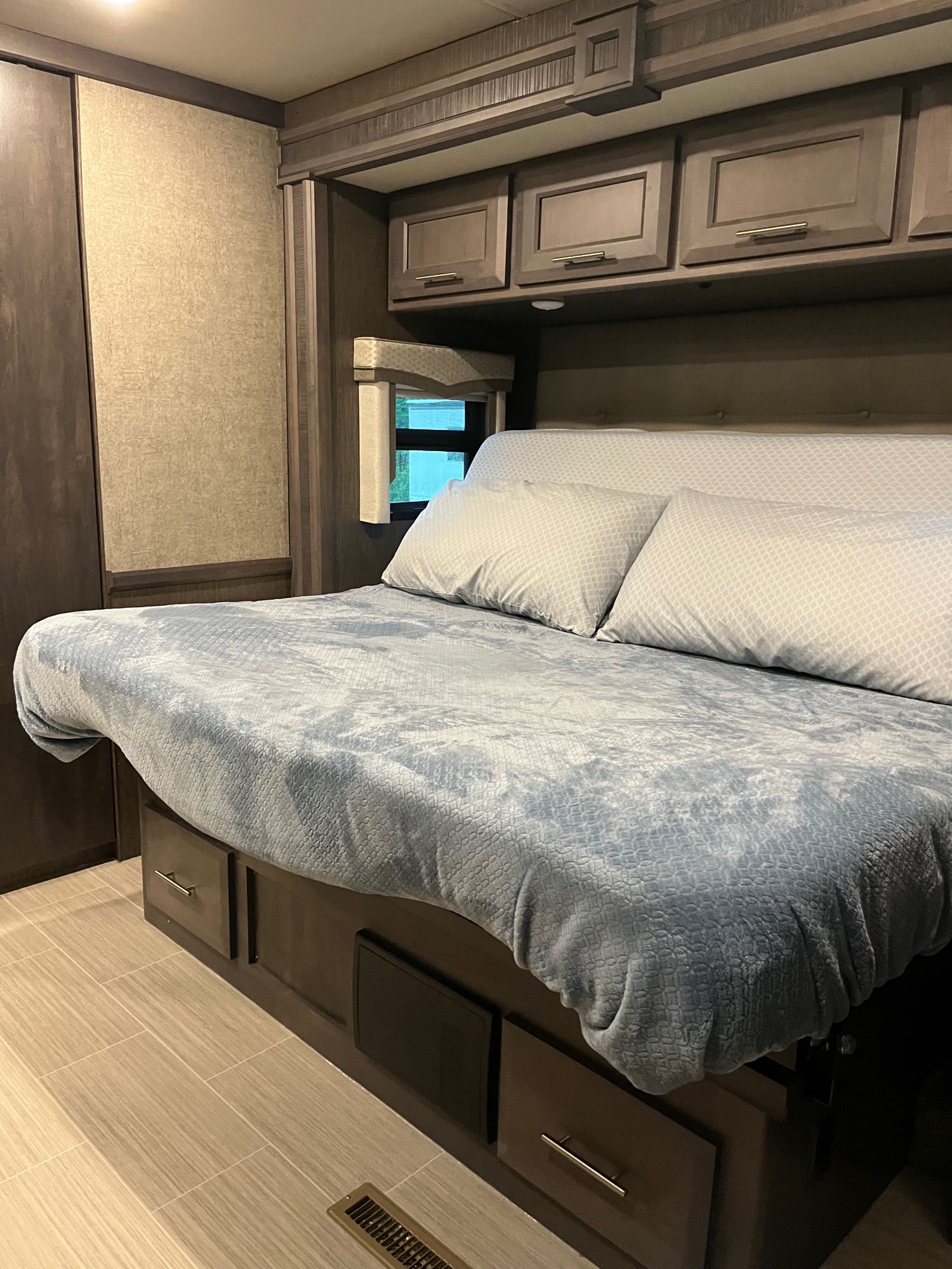 Experience comfort in this RV rental bedroom featuring a soft bed, pillows, and ample storage for your travels.. Thor Challenger 2021