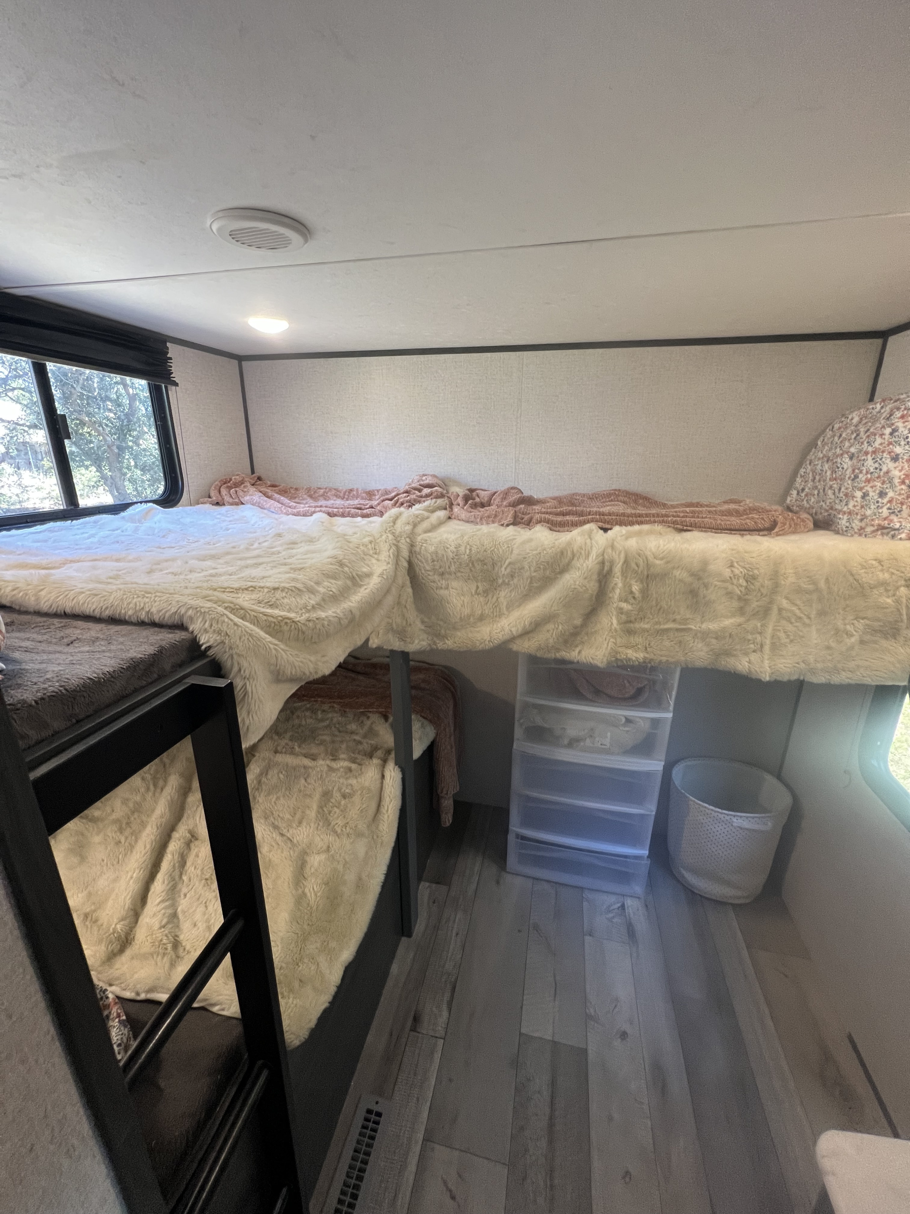 Cozy RV rental bunk beds with fluffy blankets and storage, ideal for families.. Dutchmen Aspen Trail 2021