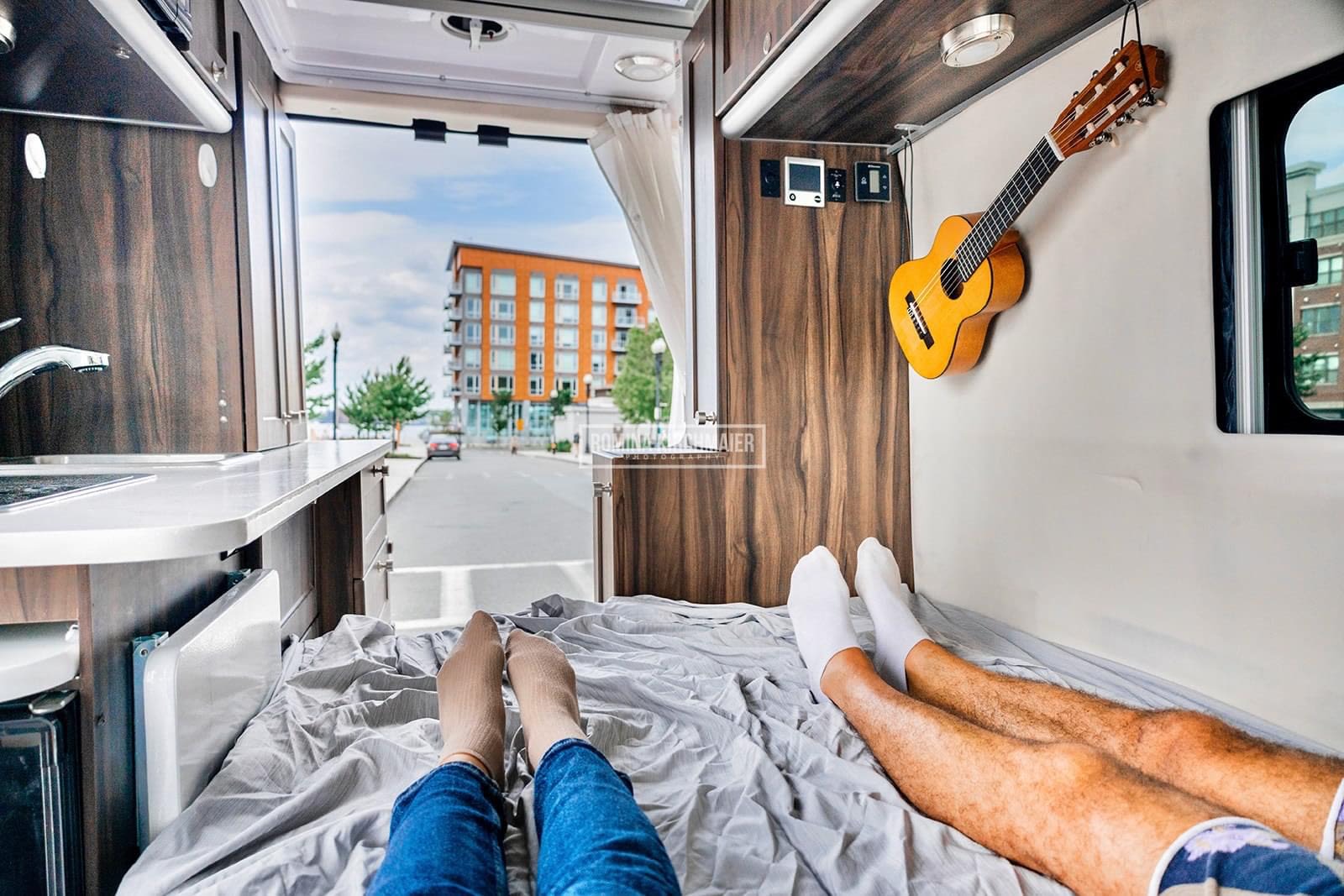 Enjoying the view from an RV rental, relaxing on the bed with a guitar nearby. Perfect for mobile adventures.. Carado Carado Class B 2017