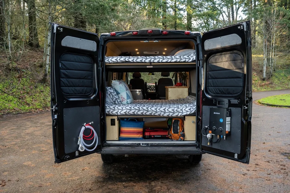 This RV rental camper van features a clever bunk bed interior with an outdoor shower and water heater.. Ram ProMaster 2021
