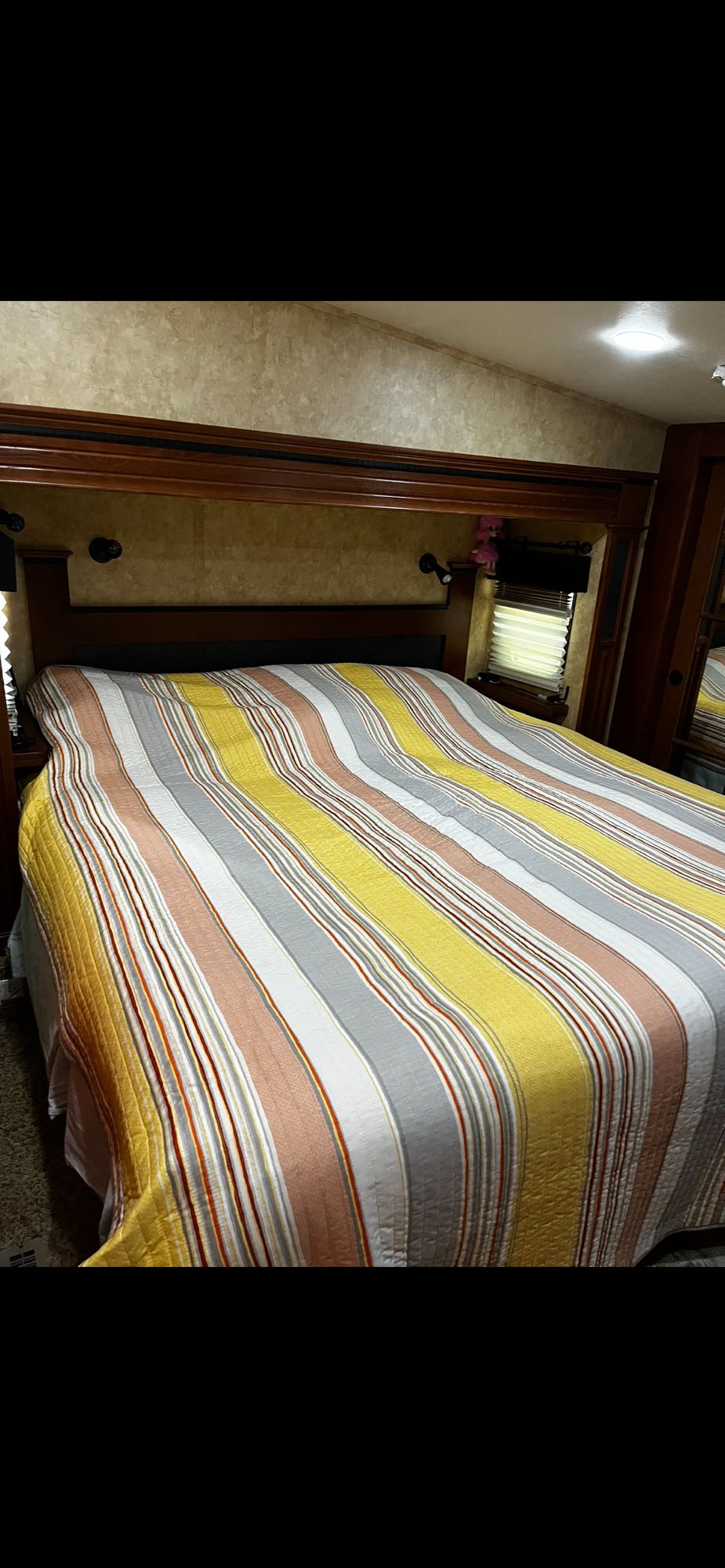 King bedroom: a cozy space with a wooden headboard and built-in reading lights.. Jayco Pinnacle 2011