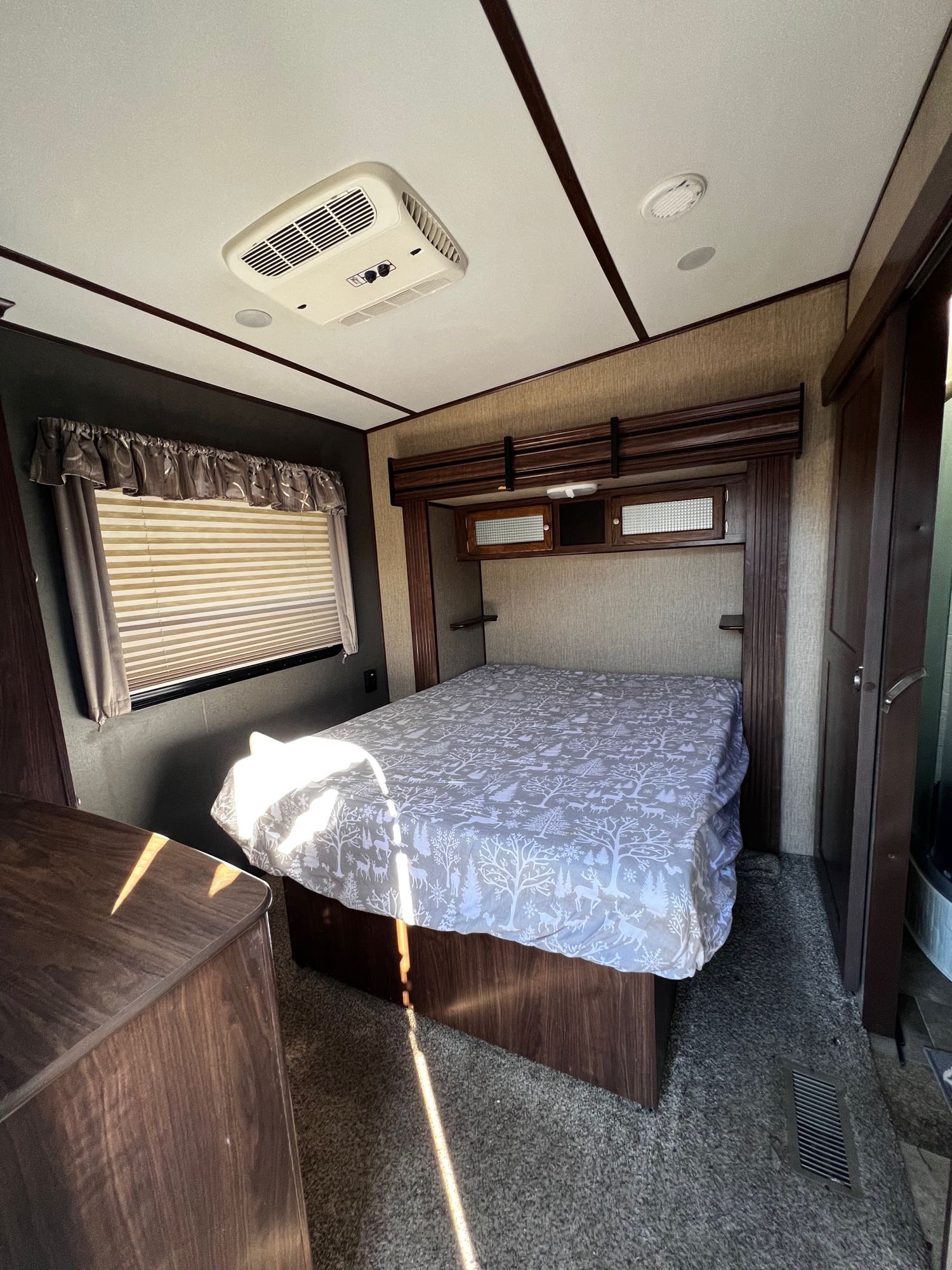 RV rental bedroom with bed, overhead storage, window, and AC unit. A compact, comfortable travel space.. Keystone RV Sprinter 2018