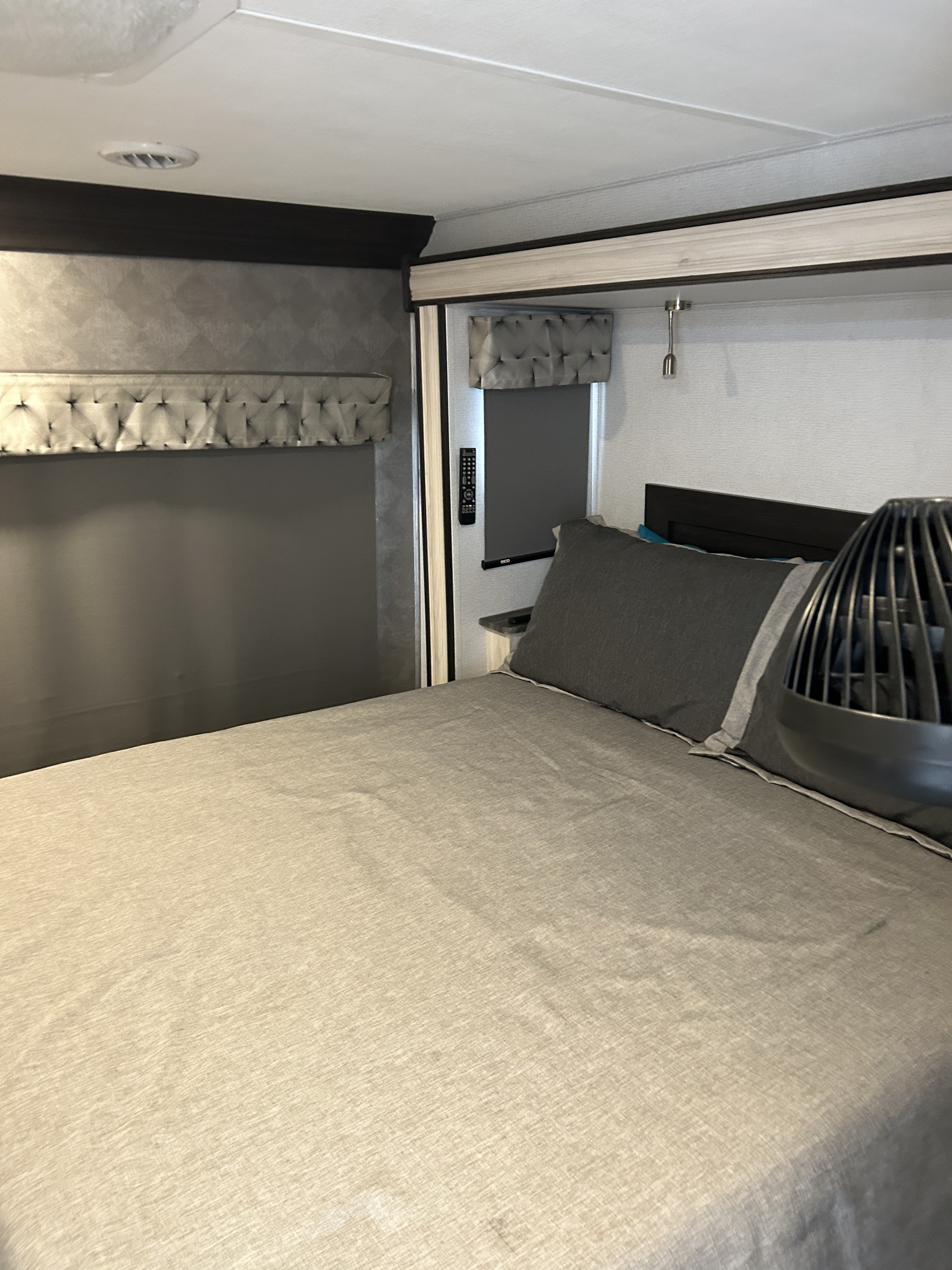 Cozy RV rental bedroom featuring a comfortable bed, fan, and built-in features for a relaxing stay.. Forest River Sunseeker Classic 2022
