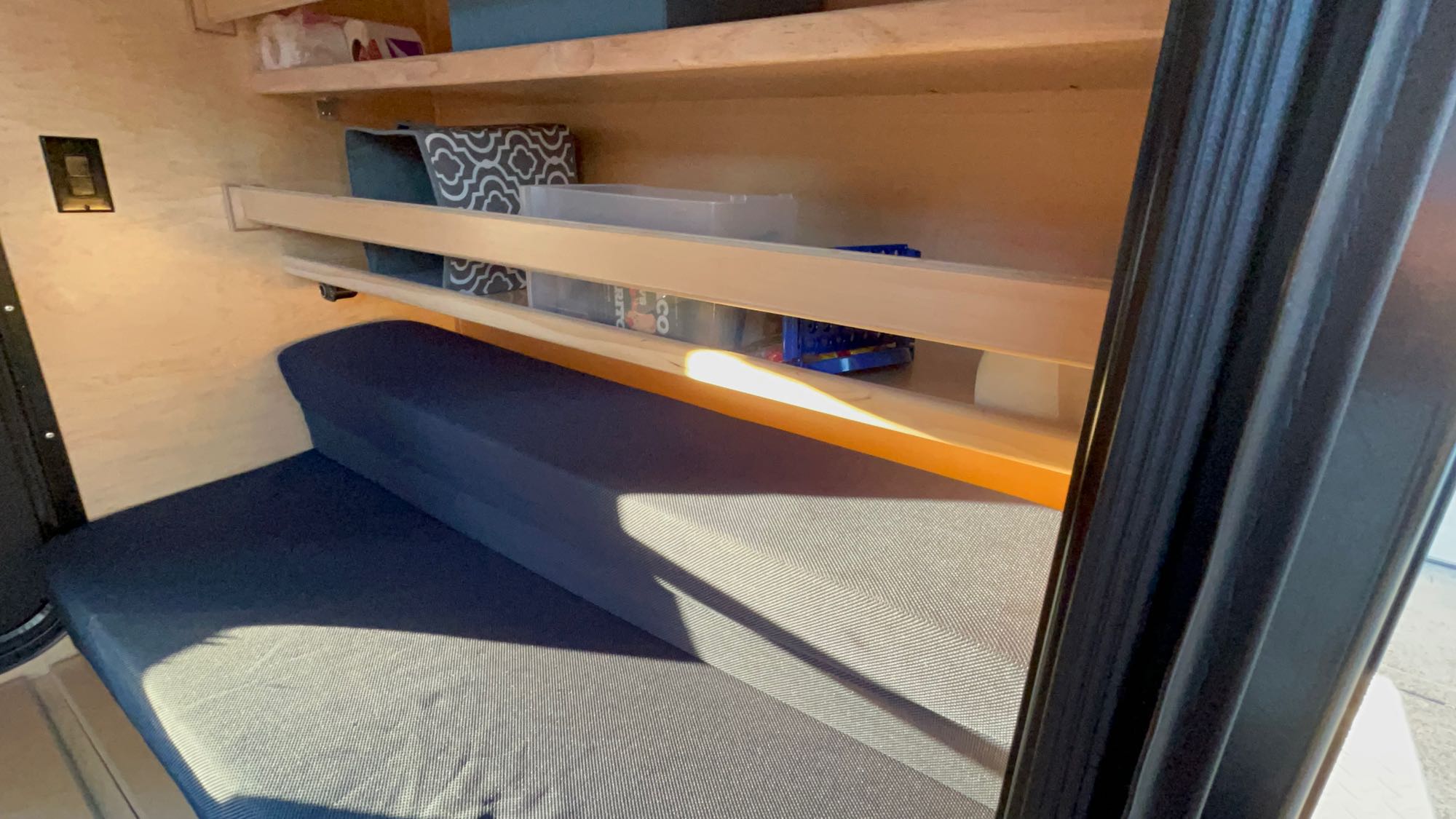 RV rental's functional interior: blue cushioned bench, wooden shelves, and compact storage.. Colorado Teardrops Mount Massive 2023