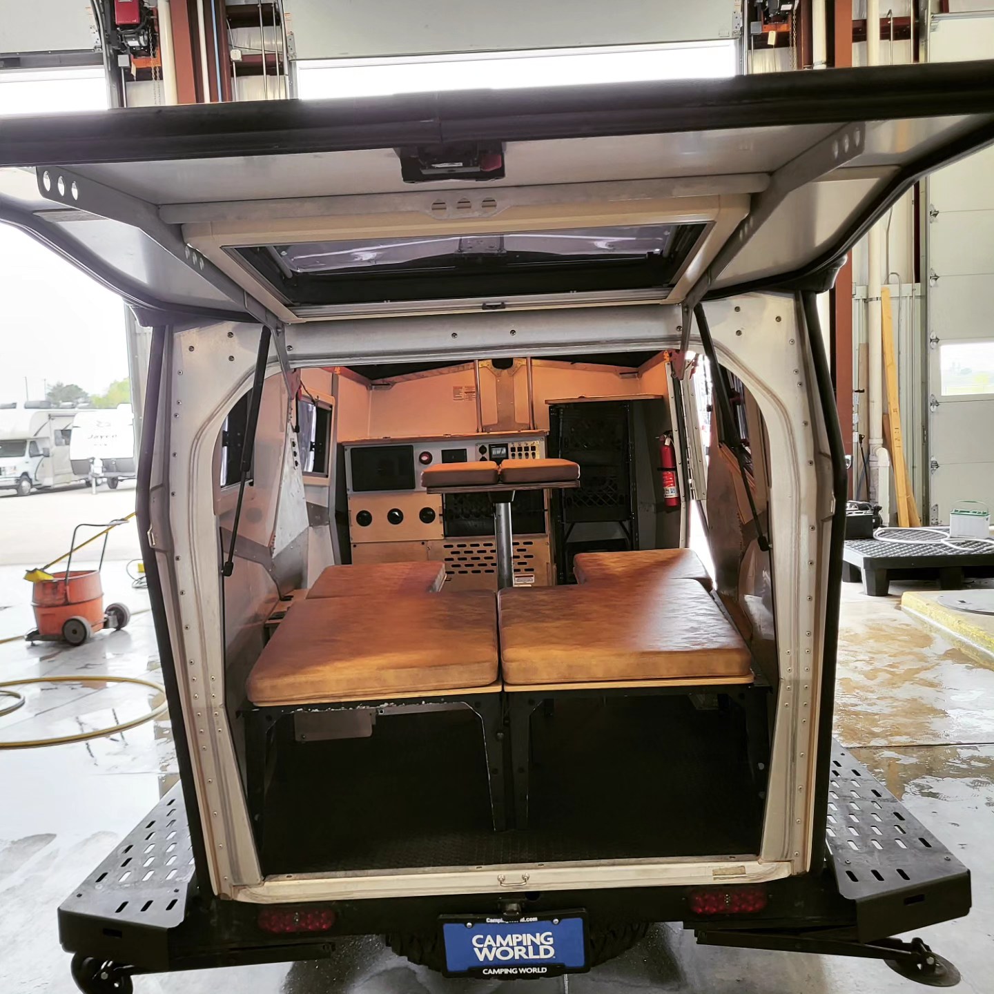 Inside an adventure RV rental from Camping World, showing the versatile living space with convertible beds and a compact kitchen.. TAXA TAXA Trailer 2021