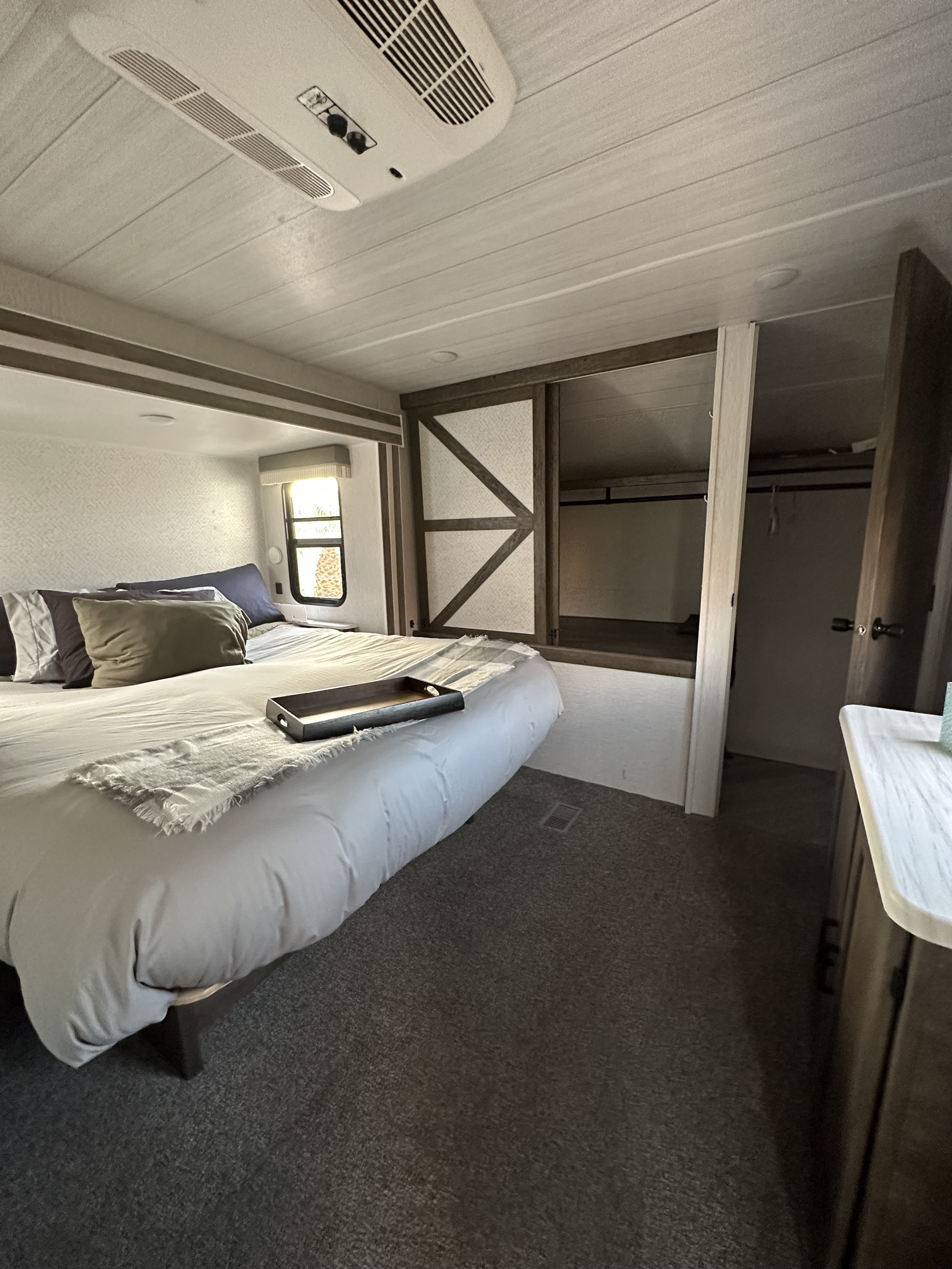 Comfortable RV rental bedroom with a cozy bed, window light, and built-in storage.. Forest River Salem 2022