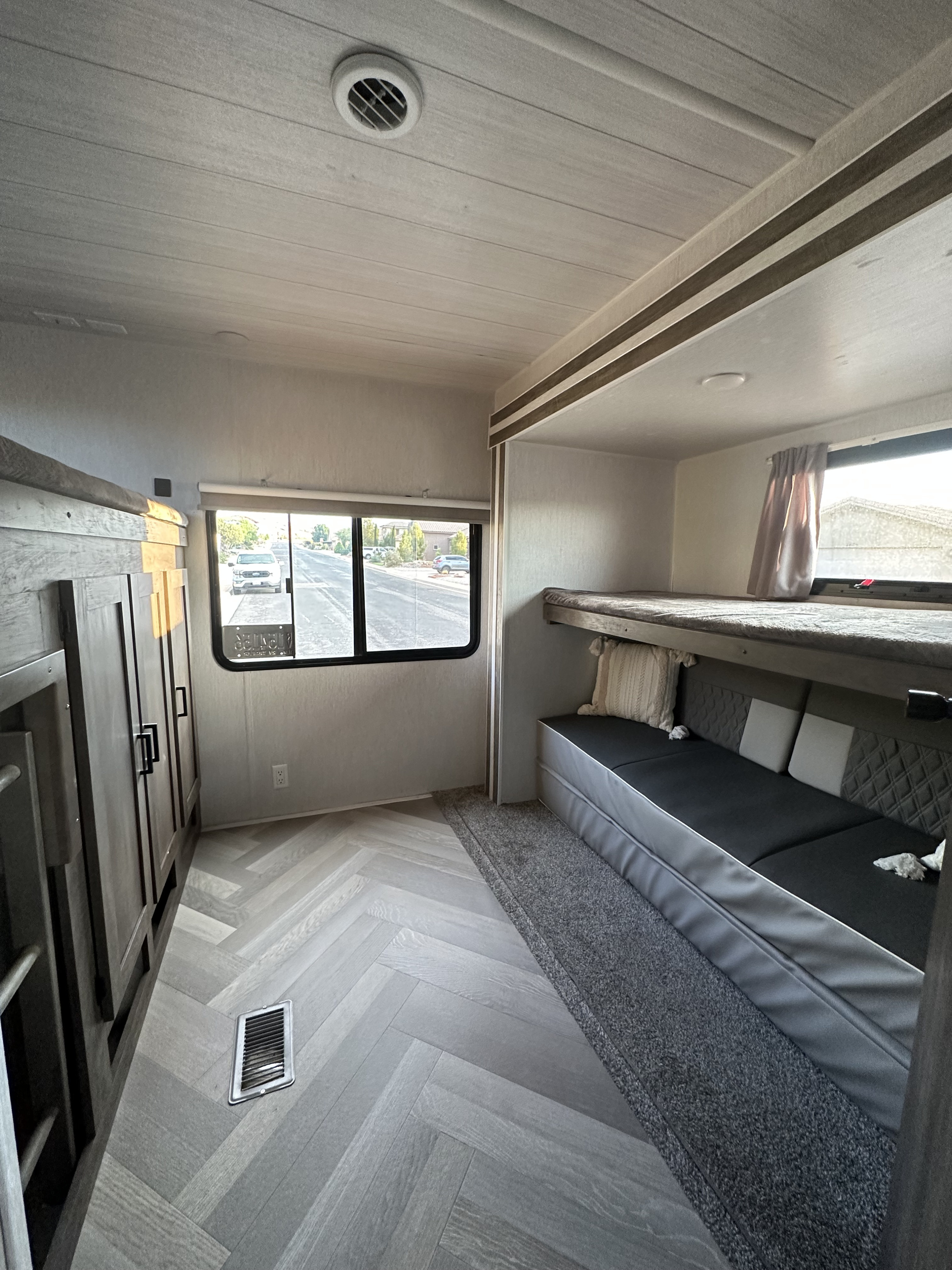 Modern RV rental interior: cozy bunk beds, a comfy seating area, and chic herringbone flooring.. Forest River Salem 2022