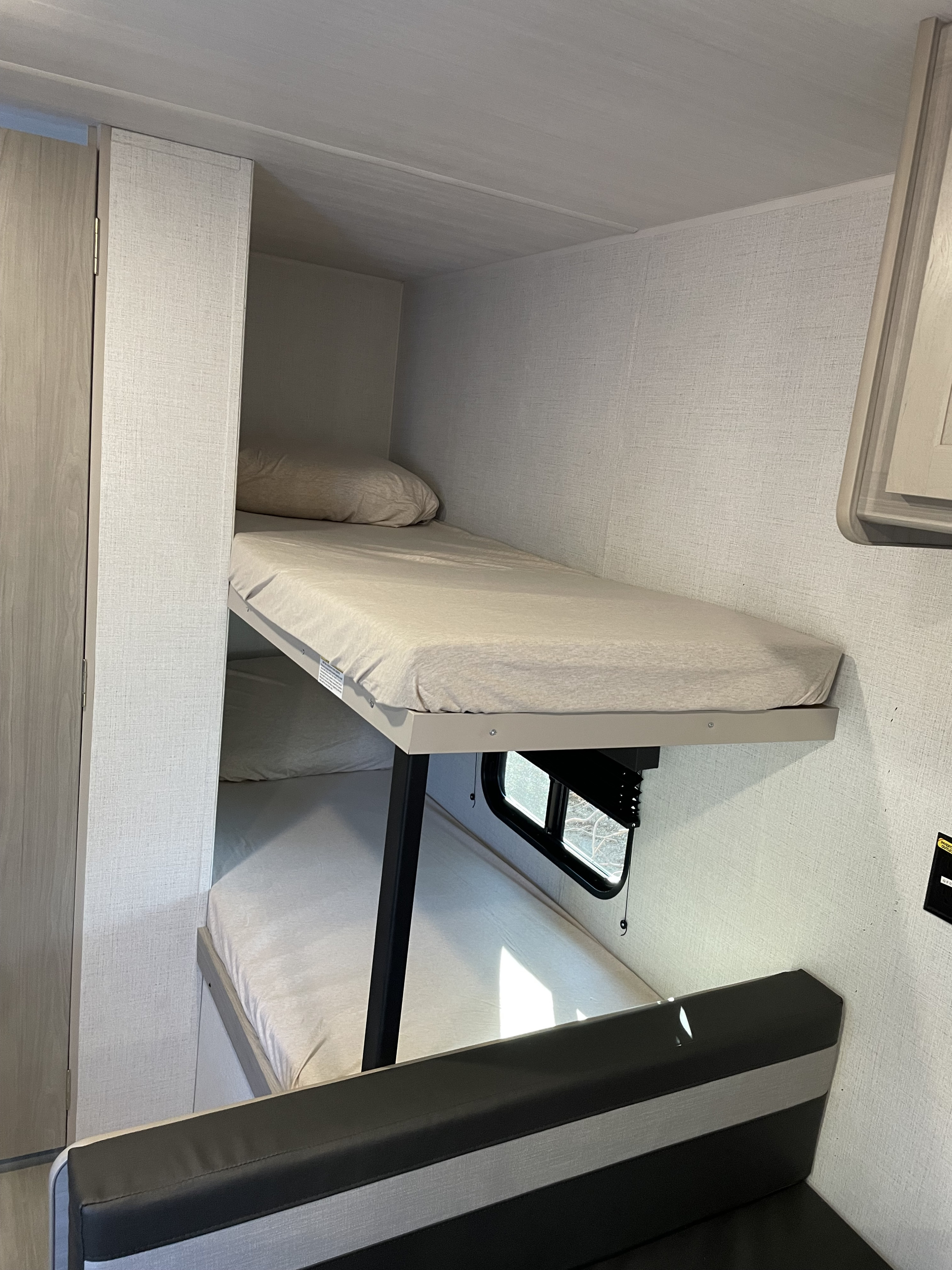 Inside an RV rental: two clean bunk beds and a seating area, ready for your next adventure.. Keystone Rv company 1800bh 2024