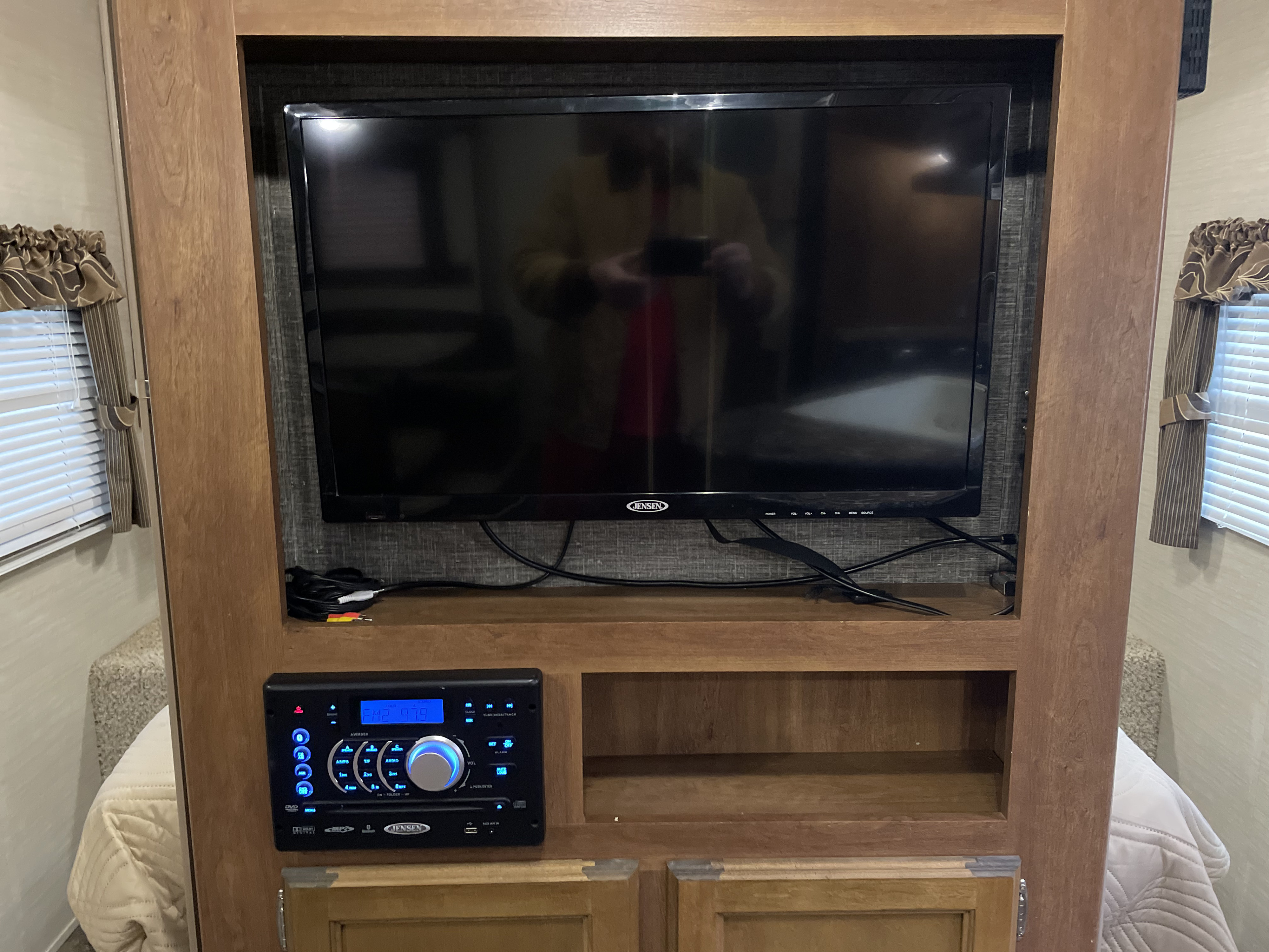 RV rental: Entertainment center with a Jensen TV and stereo system, built into the wooden interior cabinetry.. Keystone RV Springdale 2016