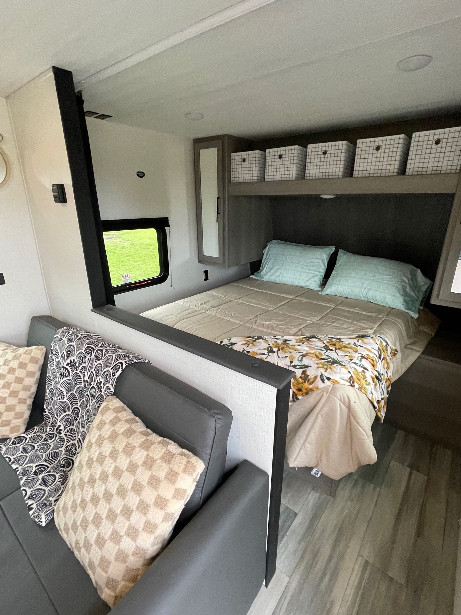 Comfortable RV rental interior featuring a compact bedroom with bed & storage, plus a cozy living area with sofa.. Keystone Hideout 240BH 2024