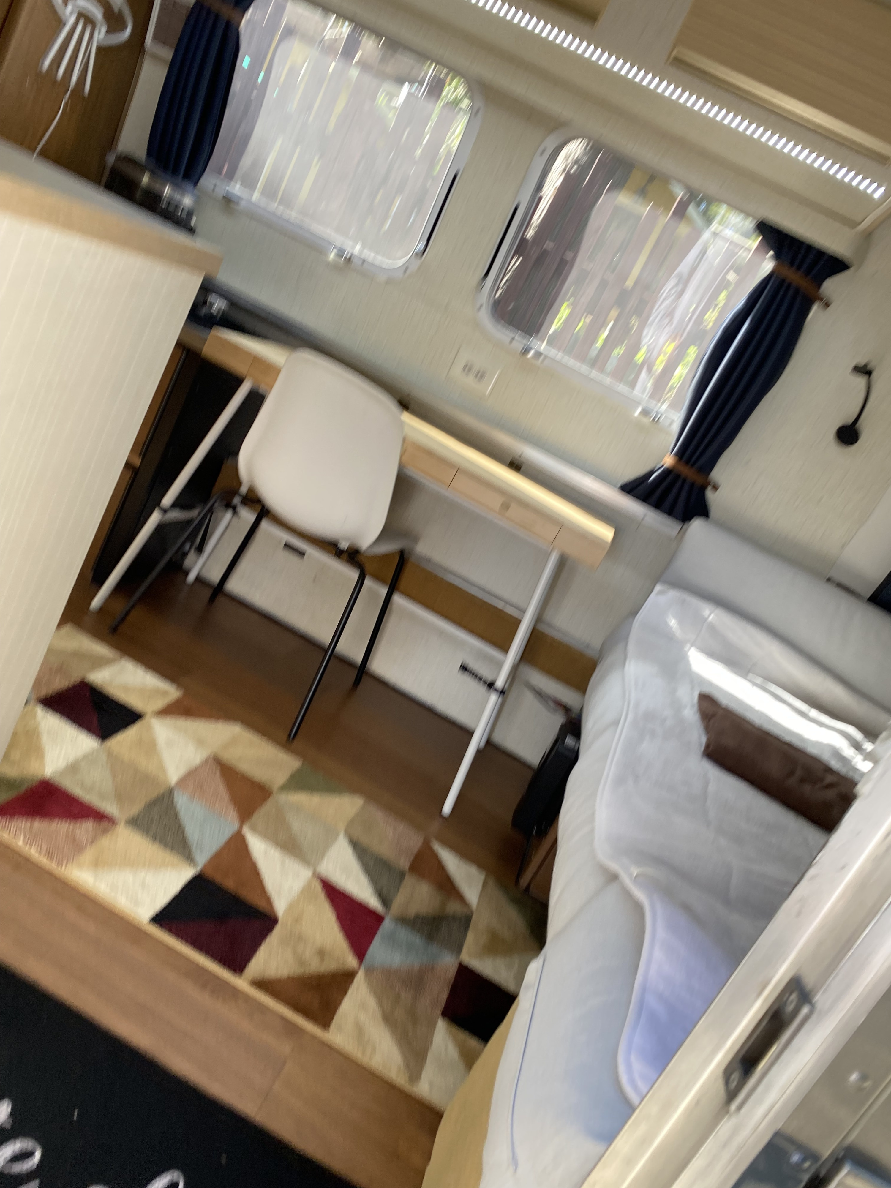 RV rental interior: workstation with chair, bed, and colorful rug. Your portable office/bedroom.. Airstream Argosy 1977