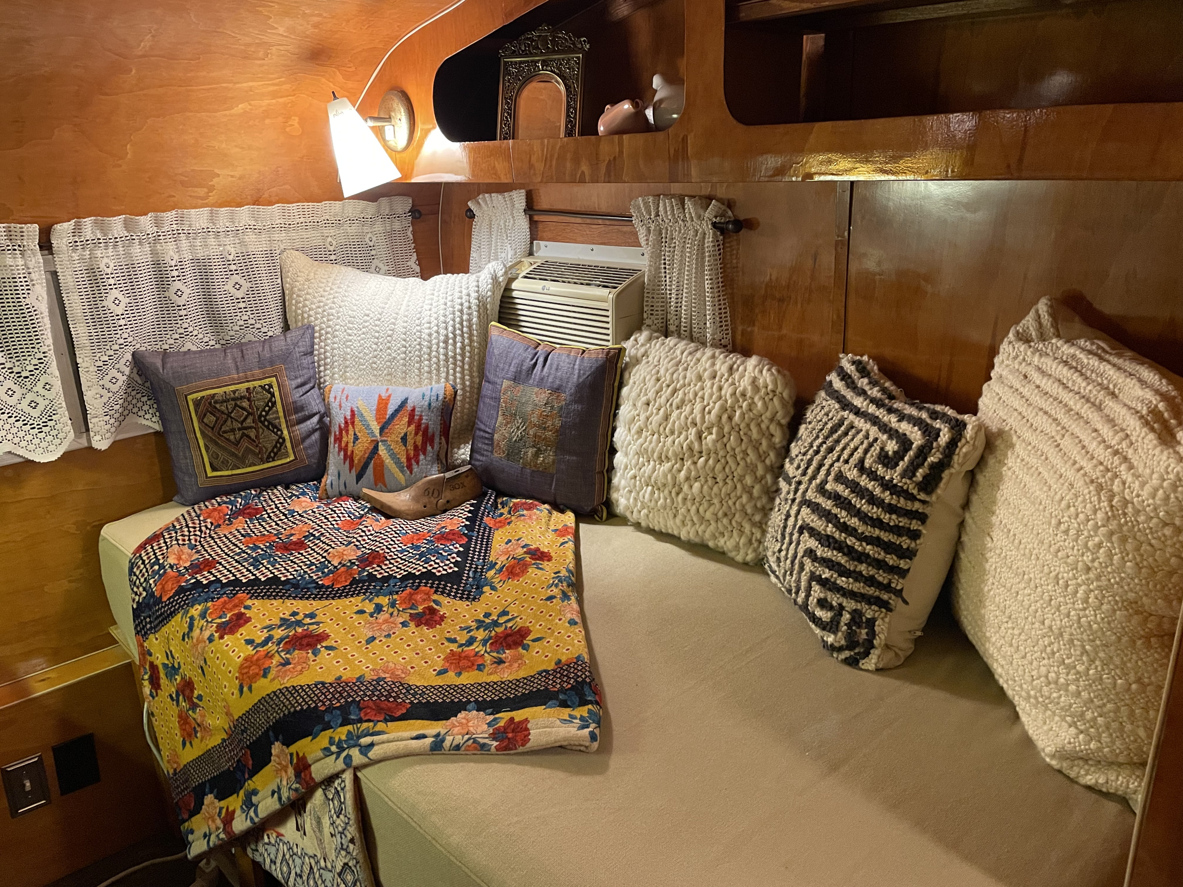 Experience a comfortable RV rental interior: soft pillows, a colorful blanket, and an AC unit for a cozy stay.. Play-Mor Other 1978