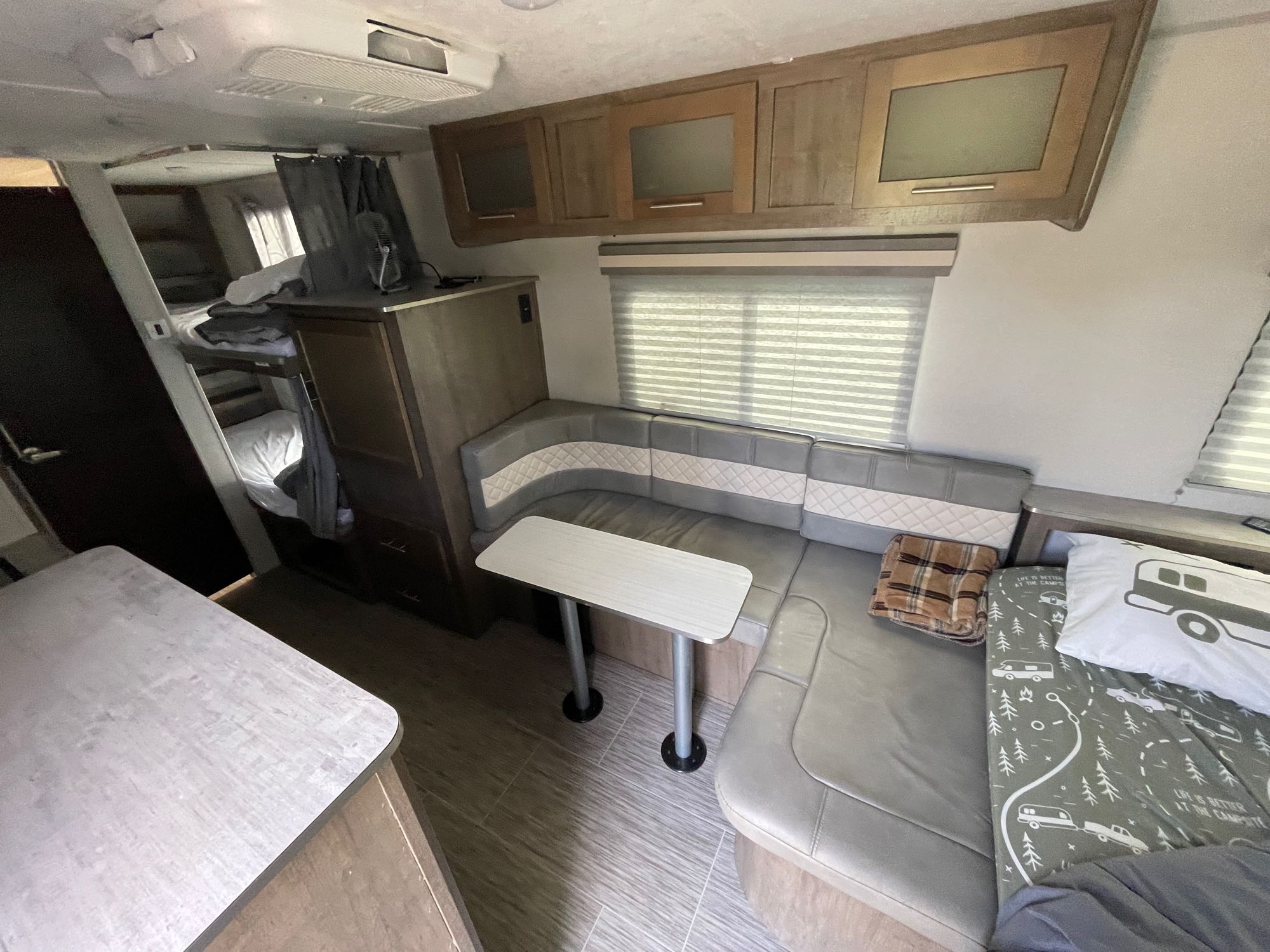 Cozy RV rental interior featuring a dinette, bunk beds, and a comfy sleeping area, ideal for travel adventures.. Forest River No Boundaries 19.7 2019