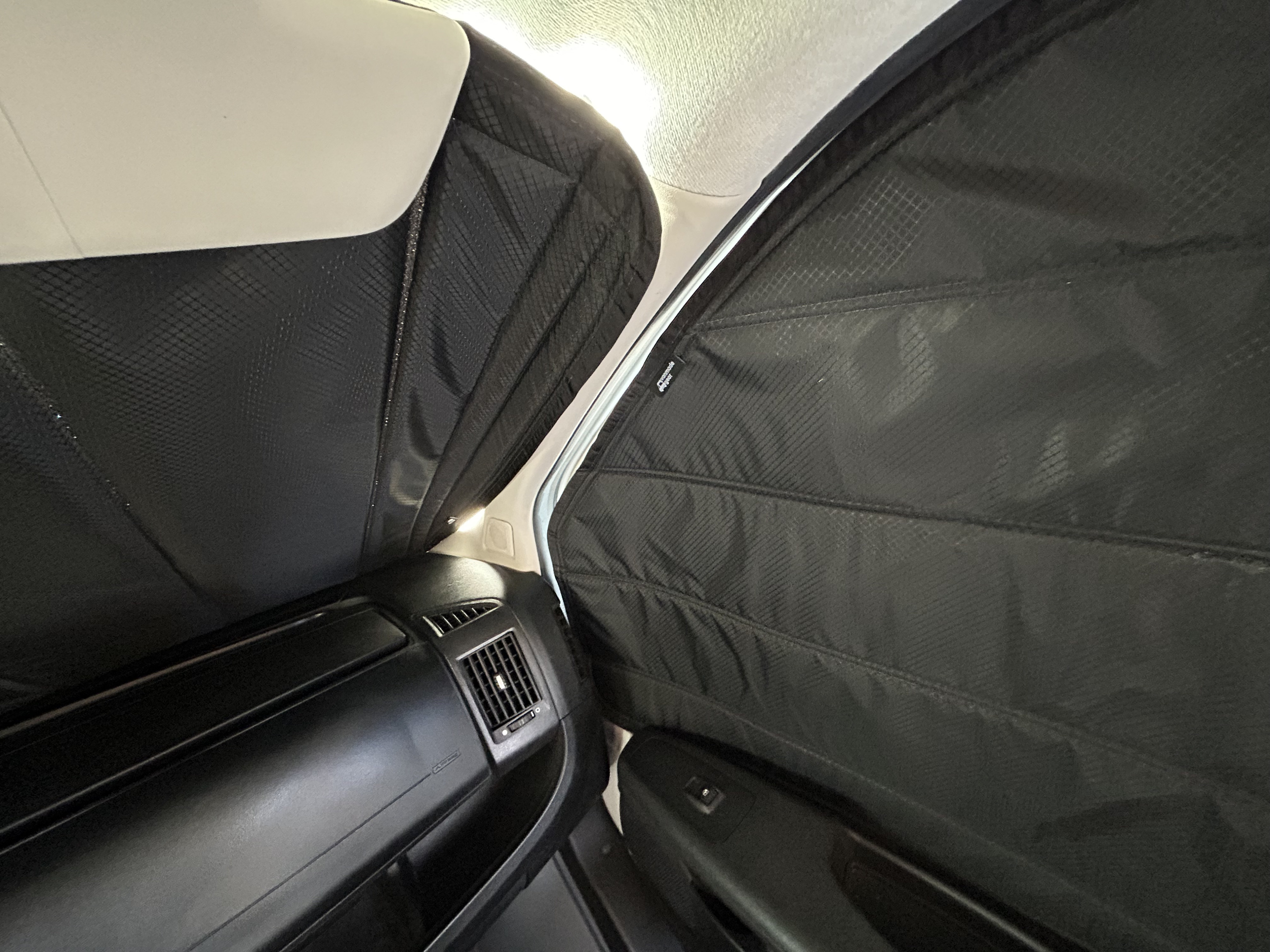 RV rental: View from inside, showcasing custom black sunshades on front and side windows for privacy/insulation, with dashboard visible.. Ram Promaster 2500 2017