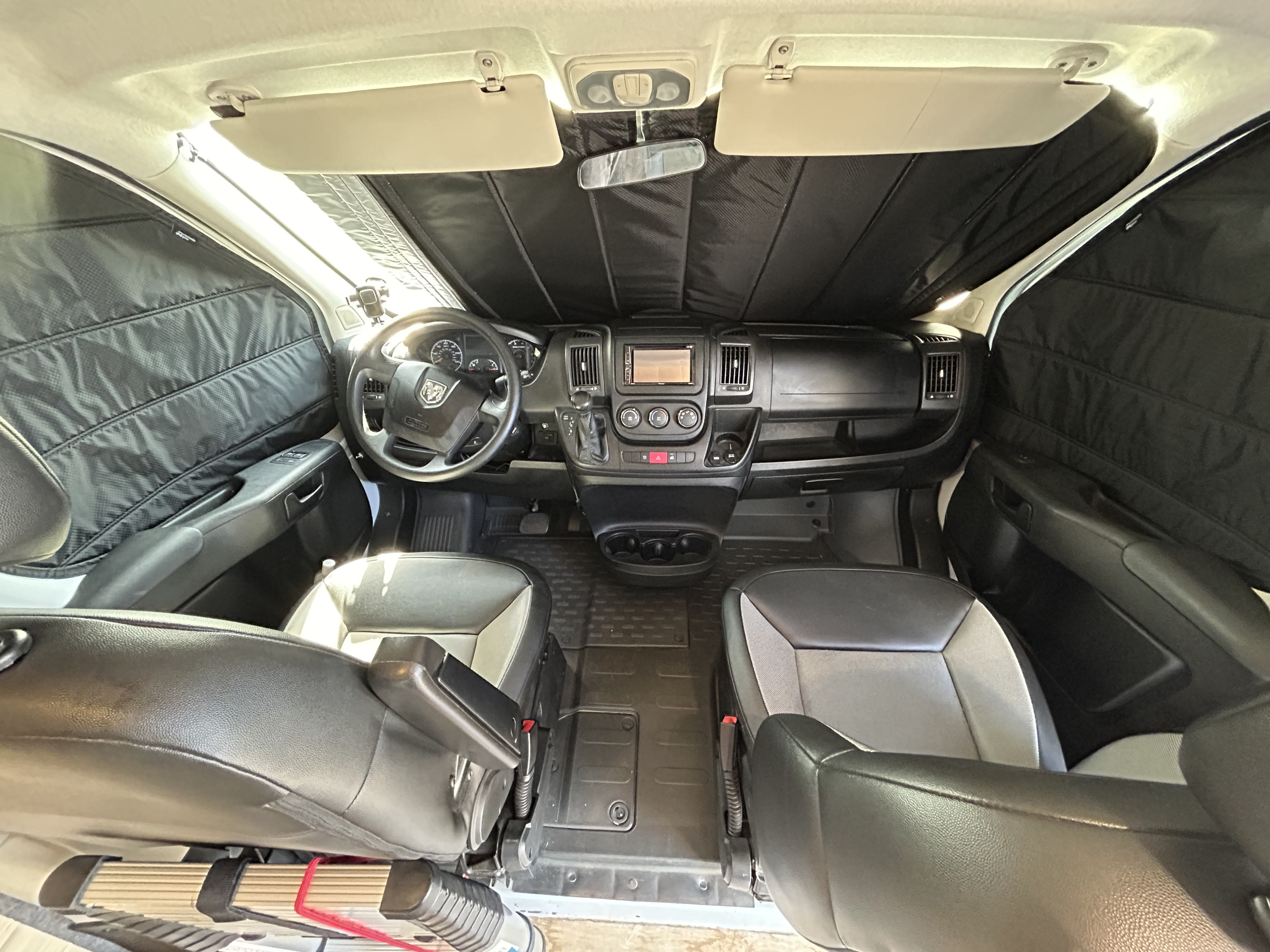 RV rental: Front cab with black window covers, dashboard, steering wheel, and two-tone seats. Ideal for privacy.. Ram Promaster 2500 2017