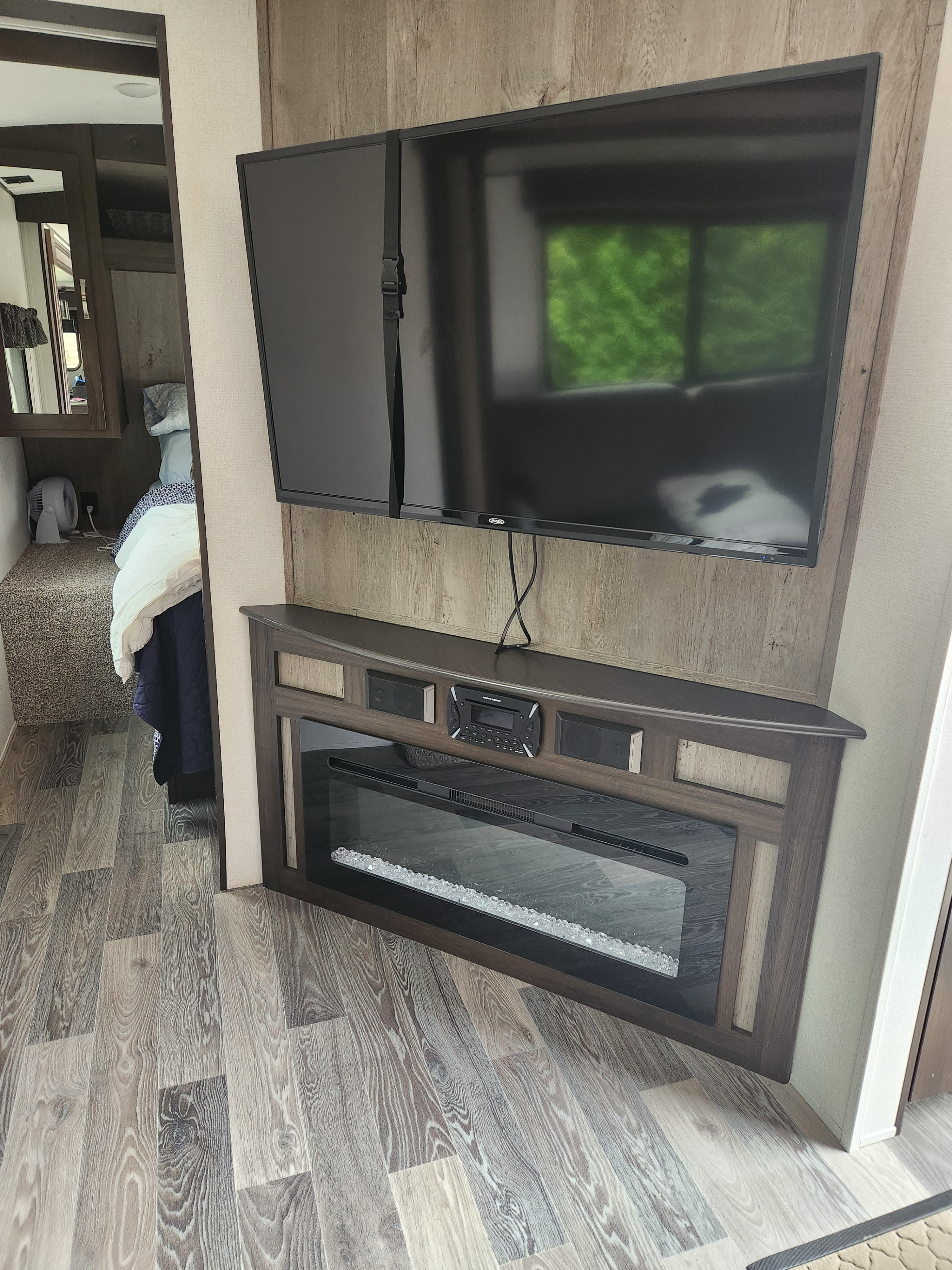 RV rental interior featuring a TV secured by a strap, electric fireplace, and entertainment system. Modern design.. Keystone RV Springdale 2021