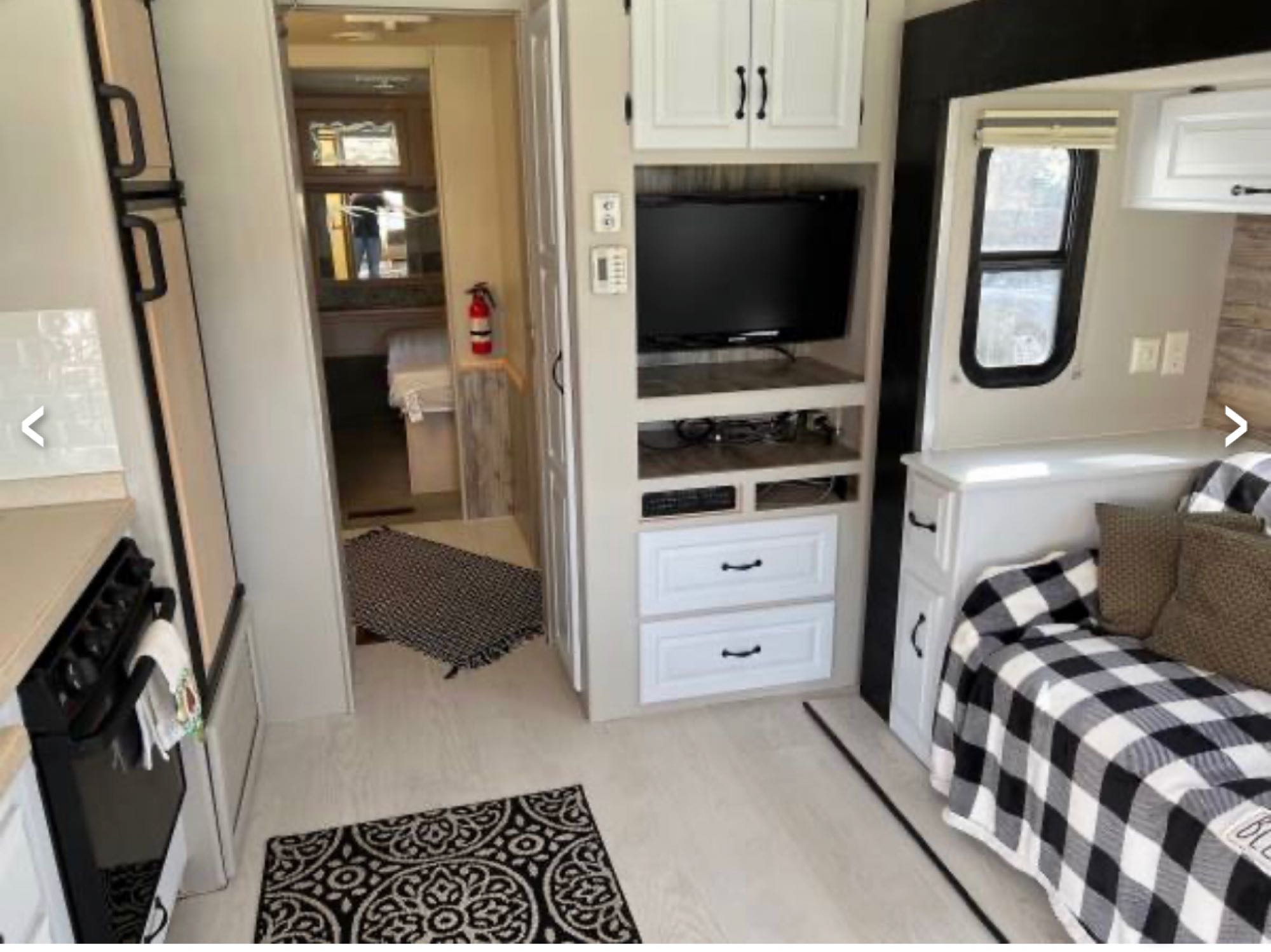 Explore this updated RV rental interior: a clean kitchen, entertainment center with TV, and cozy seating/bed area.. Newmar Dutch Star Motorhome 2002