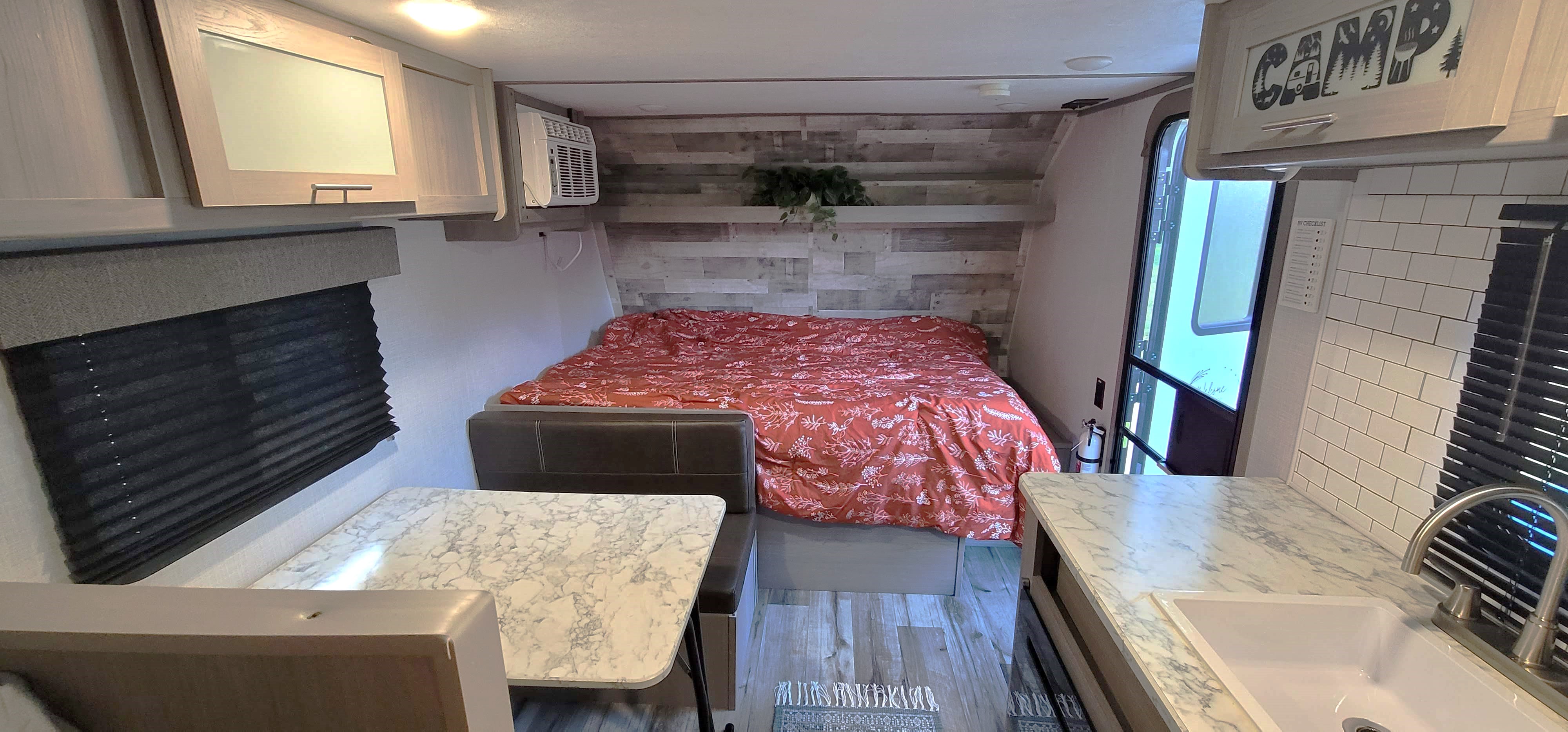 Cozy RV rental interior showcasing a full bed, dinette, and kitchen area, ready for your next travel adventure.. Dutchmen Coleman Lantern LT 2022