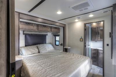 Comfortable RV rental bedroom with a large bed, overhead storage, and private bath entrance. Ideal for travel.. FR3 FR3 Motorhome 2022