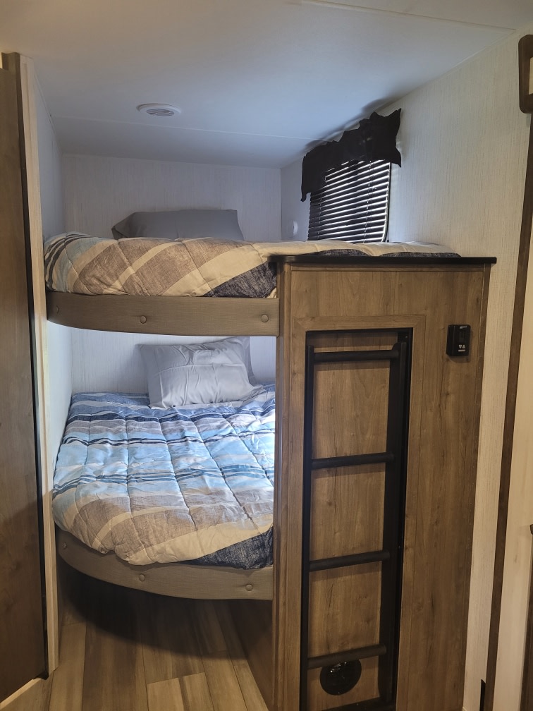 This RV rental features comfortable bunk beds, providing cozy sleeping arrangements in a modern camper interior.. Heartland Pioneer 2024